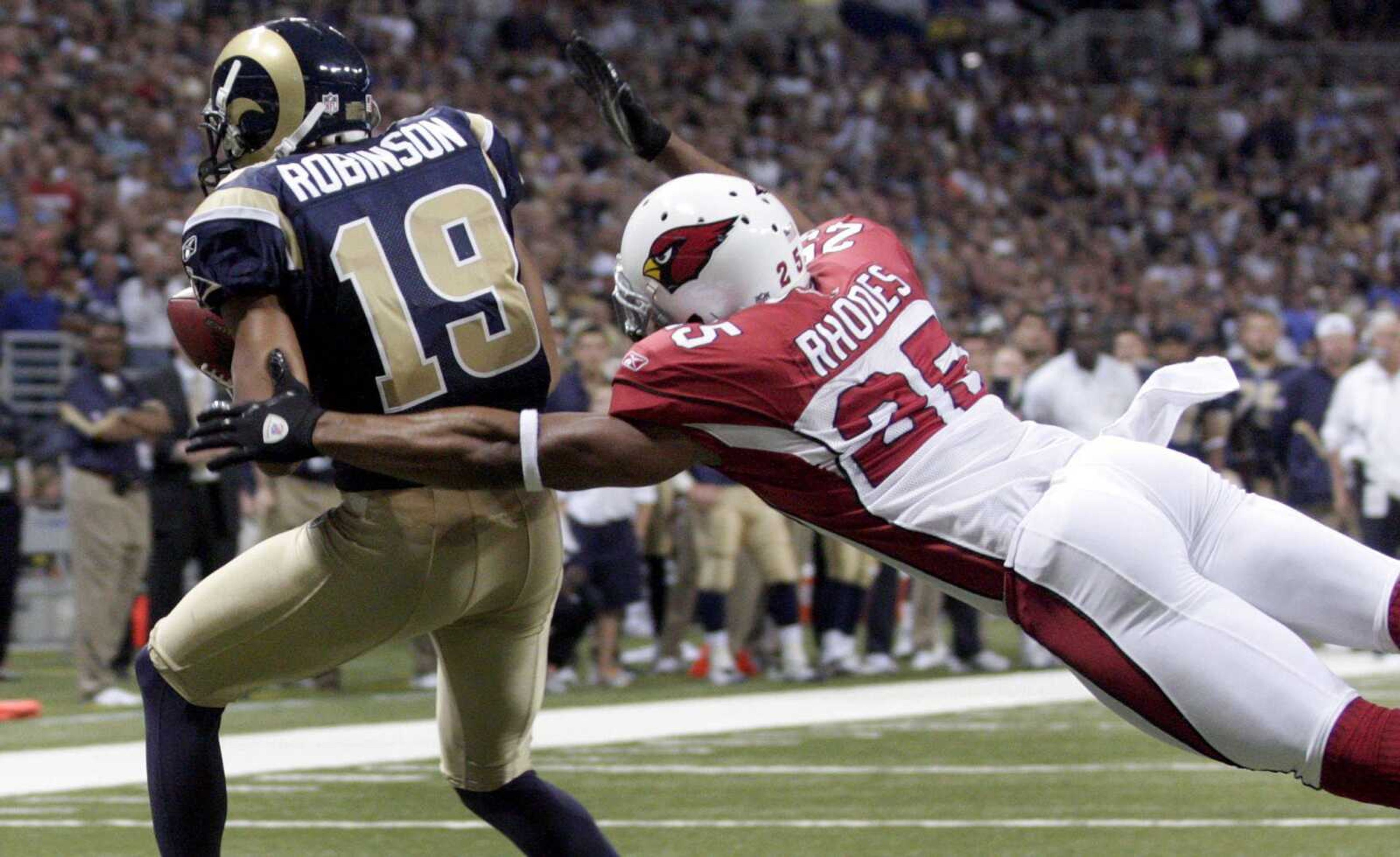 Rams receiver Laurent Robinson catches a 1-yard touchdown pass as Cardinals safety Kerry Rhodes defends on the final play of the first half Sunday in St. Louis. (Tom Gannam ~ Associated Press)