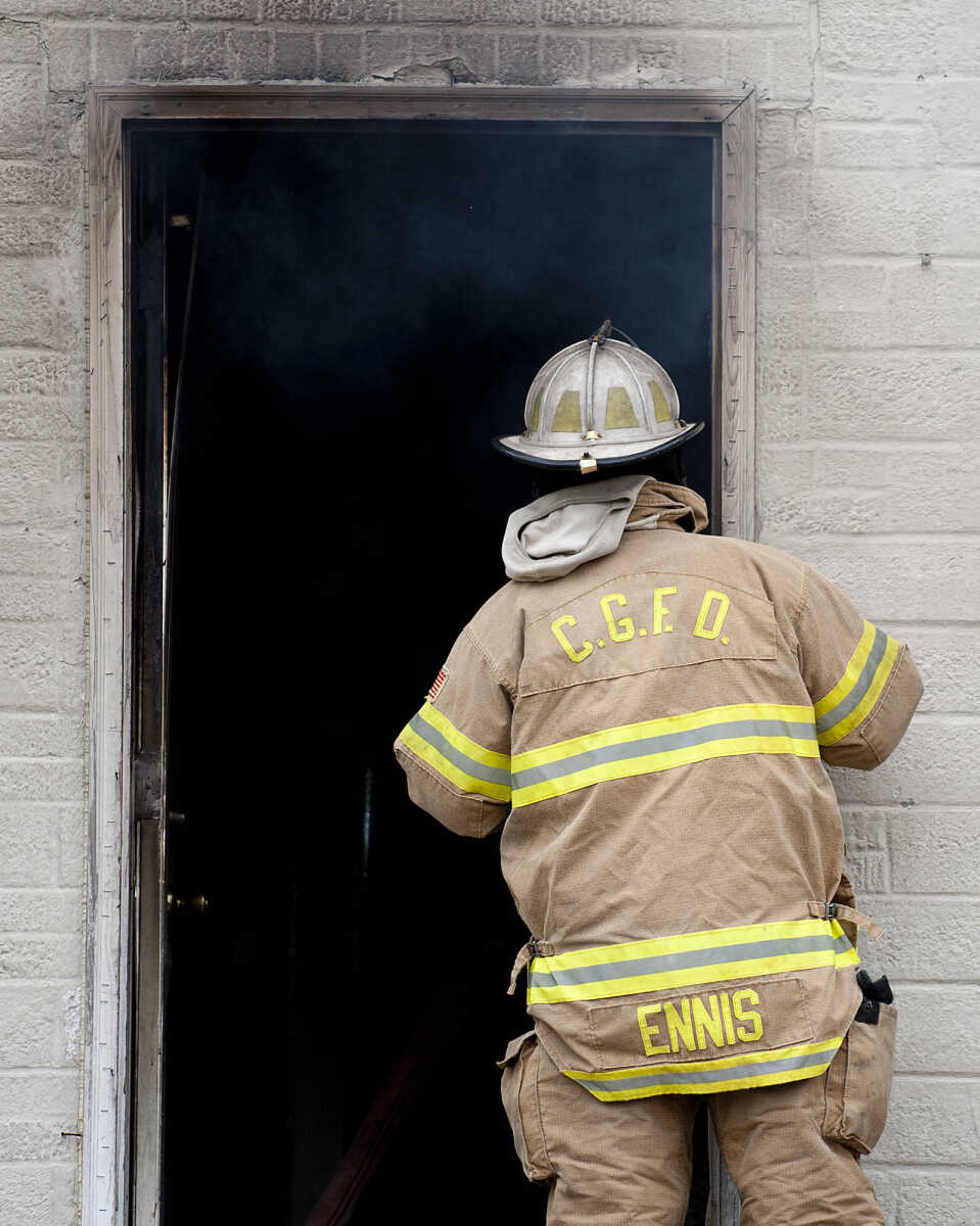 A firefighter peers in the door of a building at 710 Morgan Oak St., as the Cape Girardeau Fire Department battles a structure fire Tuesday, April 29, in Cape Girardeau. A Cape Girardeau Police officer saw the fire and called it in at 1:16 p.m. The building contained two apartments that were home to five people, though no one was home at the time of the fire. The cause of the fire is under investigation.