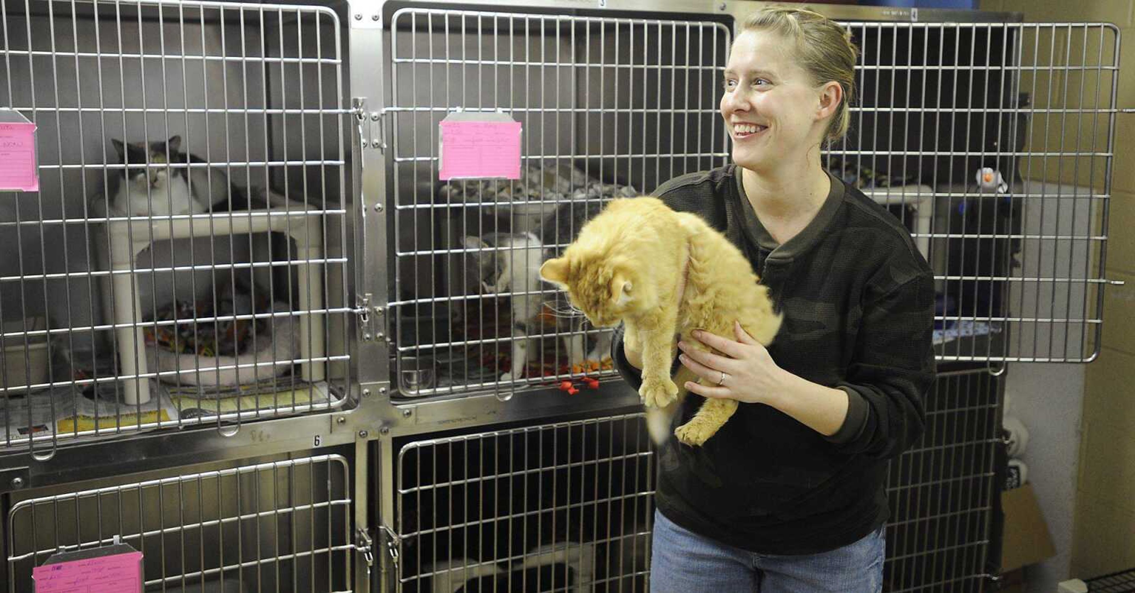 Volunteer Susan Krosunger holds Peter, who is described by the staff as the "Best cat ever!" Tuesday, Dec. 25, at the Humane Society of Southeast Missouri. Volunteers took over the normal duties at the humane society so the full-time staffers could spend Christmas with their families. This is the second year that Krosunger, who lives in State College, Pa., has volunteered at the shelter on Christmas while visiting family in Cape Girardeau. (ADAM VOGLER)