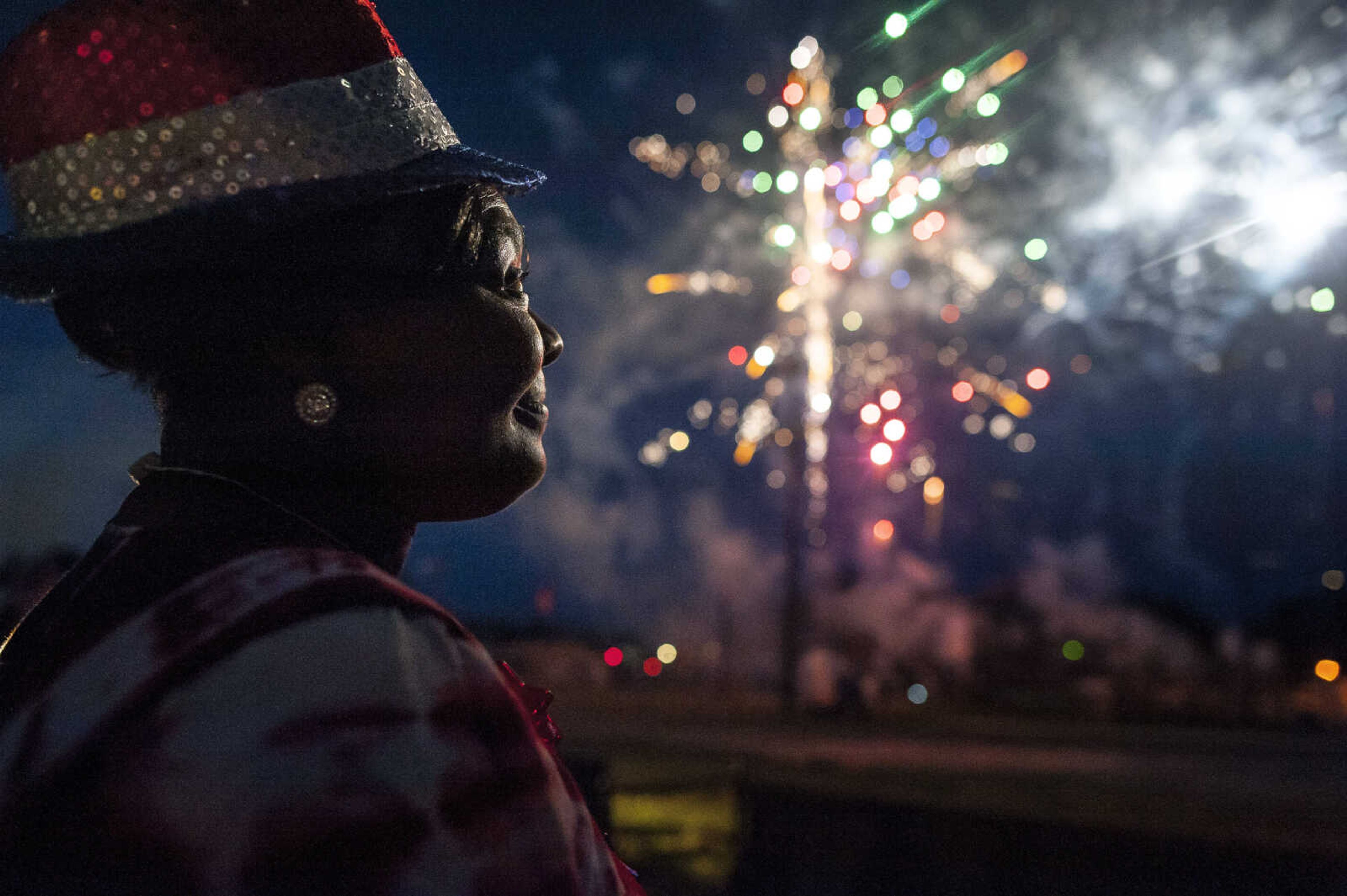 A spectator in patriotic garb is illuminated by fireworks during the annual Independence Day fireworks display Thursday, July 4, 2019, Arena Park in Cape Girardeau.