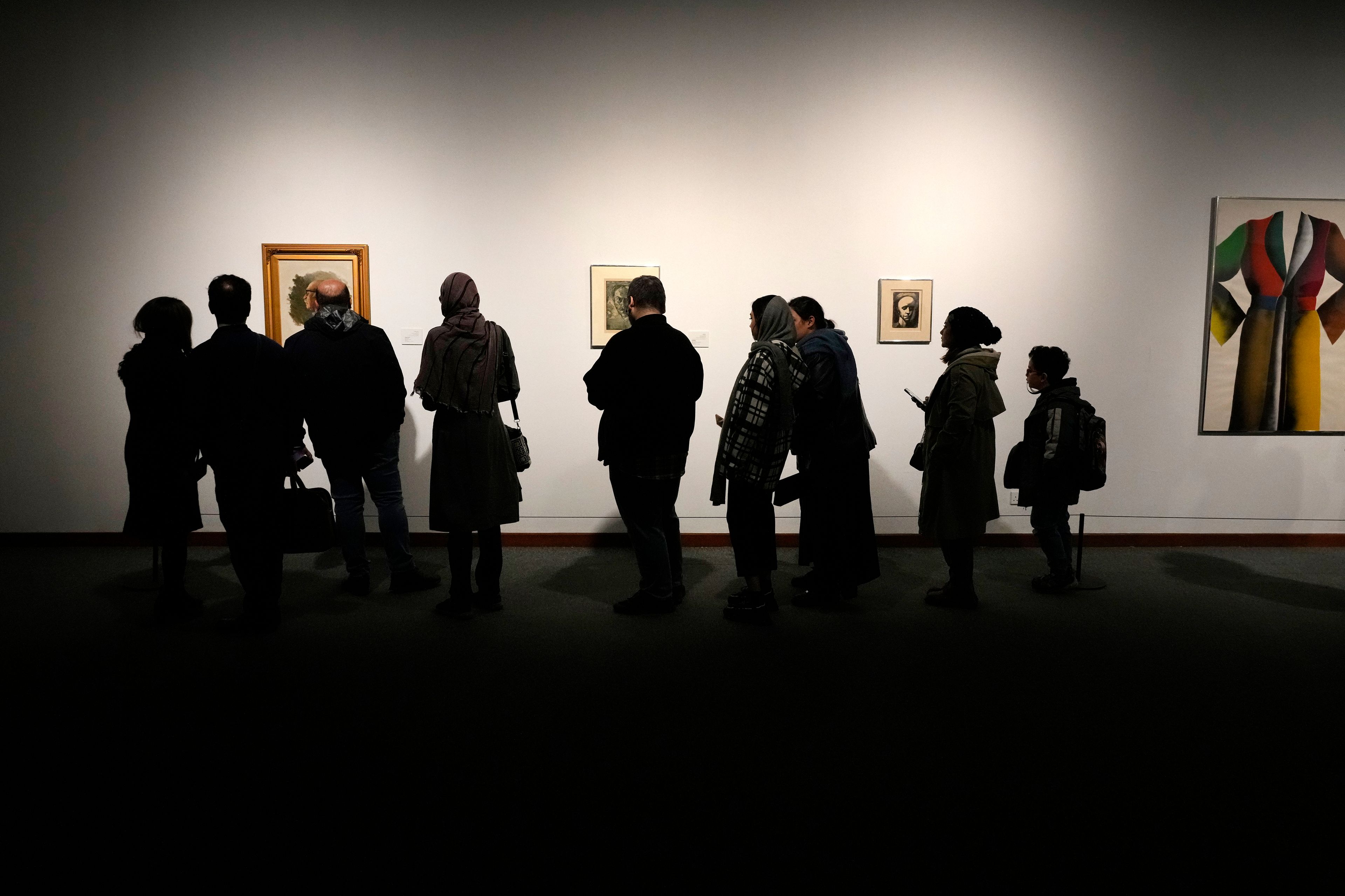 People visit an exhibition titled Eye to Eye which showcases over 120 works by modern world artists as well as Iranian painters at Tehran Museum of Contemporary Art, in Tehran, Thursday, Nov. 21, 2024. (AP Photo/Vahid Salemi)