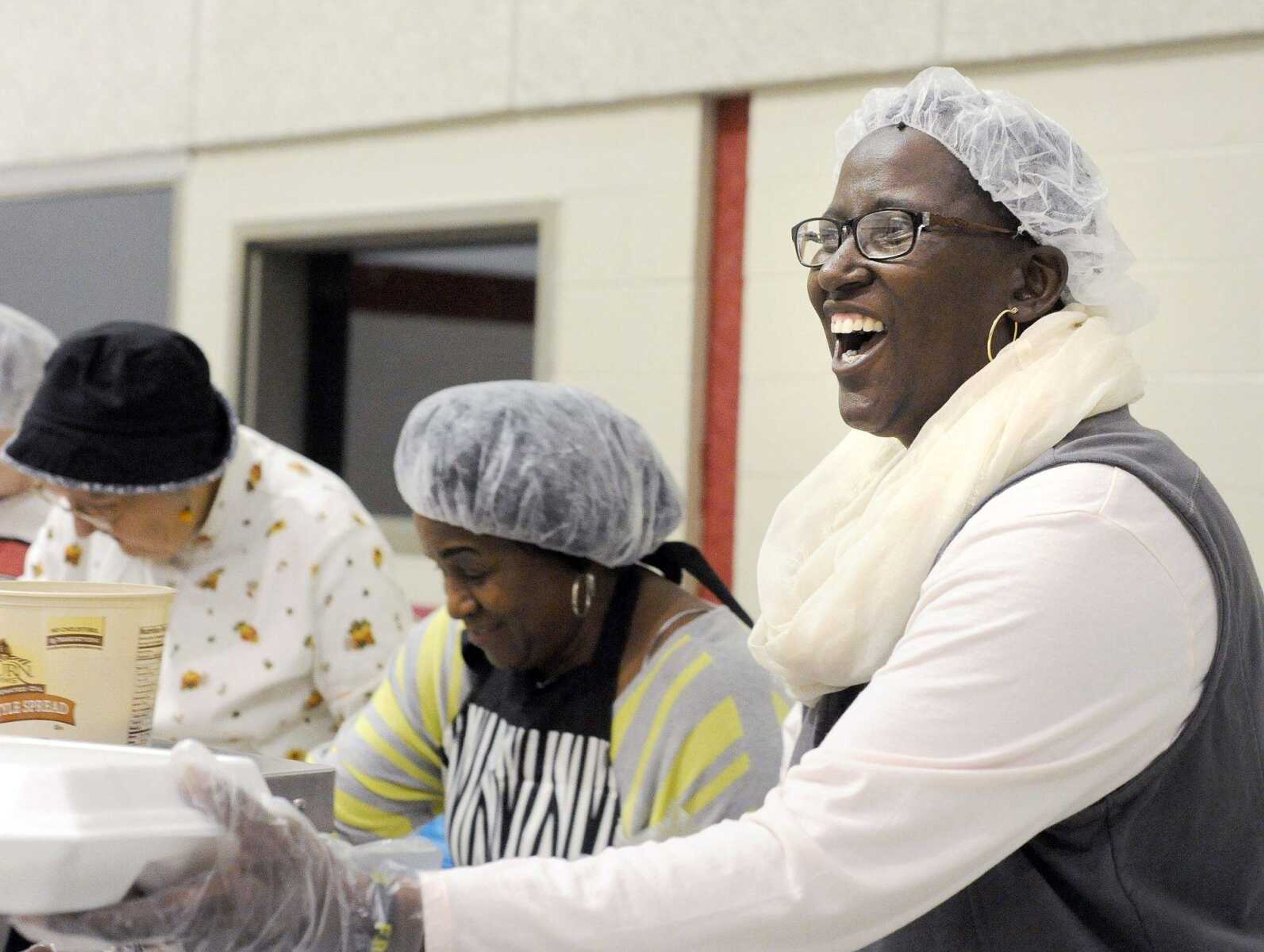 Bertha King shares a laugh while handing out carry-out orders Thursday during Thanksgiving lunch at the Salvation Army in Cape Girardeau. (Laura Simon)