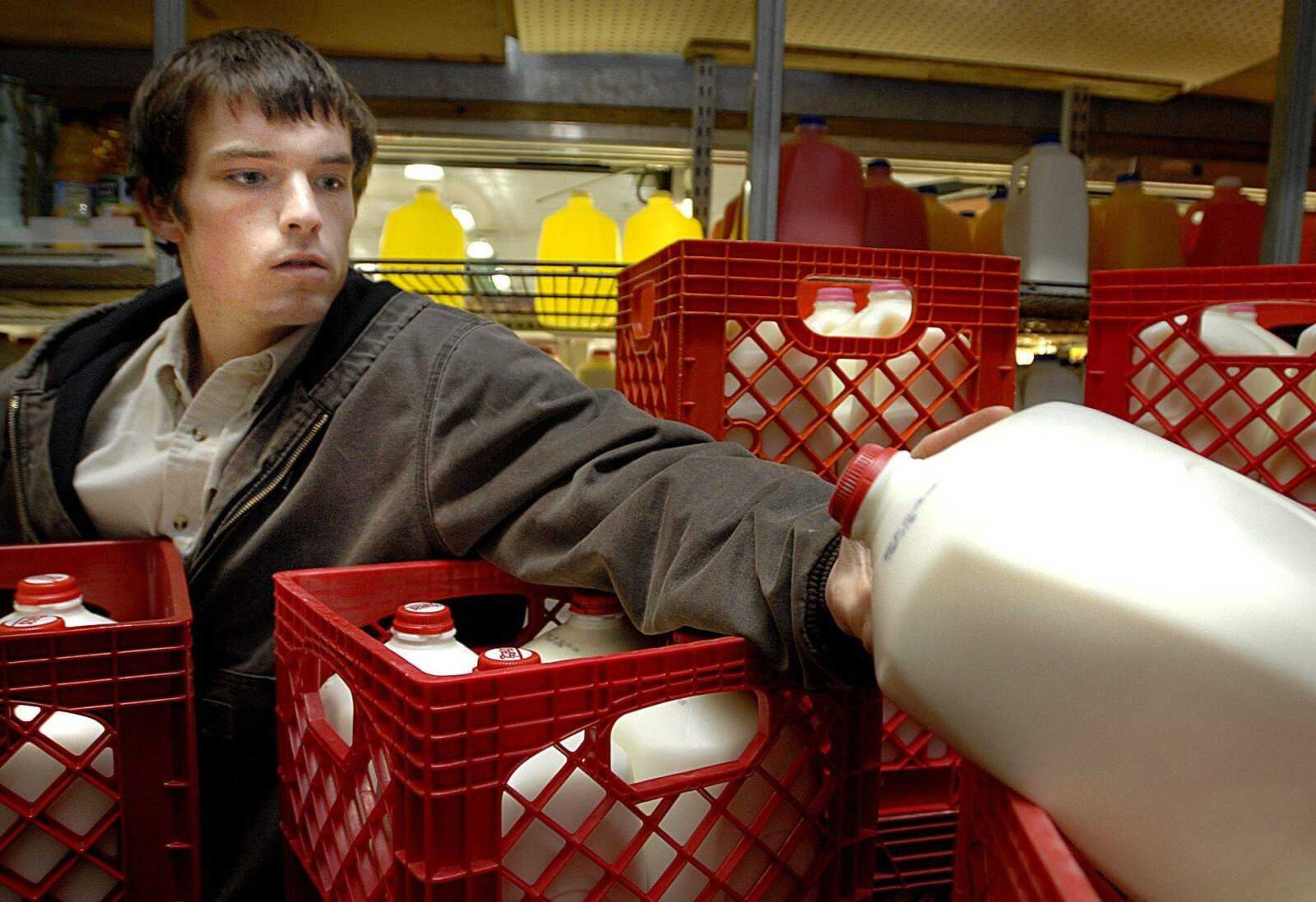 Matt Mueller checked the date on a gallon of Prairie Farms whole milk Monday as he stocked the shelves in the cooler at Country Mart in Jackson. (Aaron Eisenhauer)