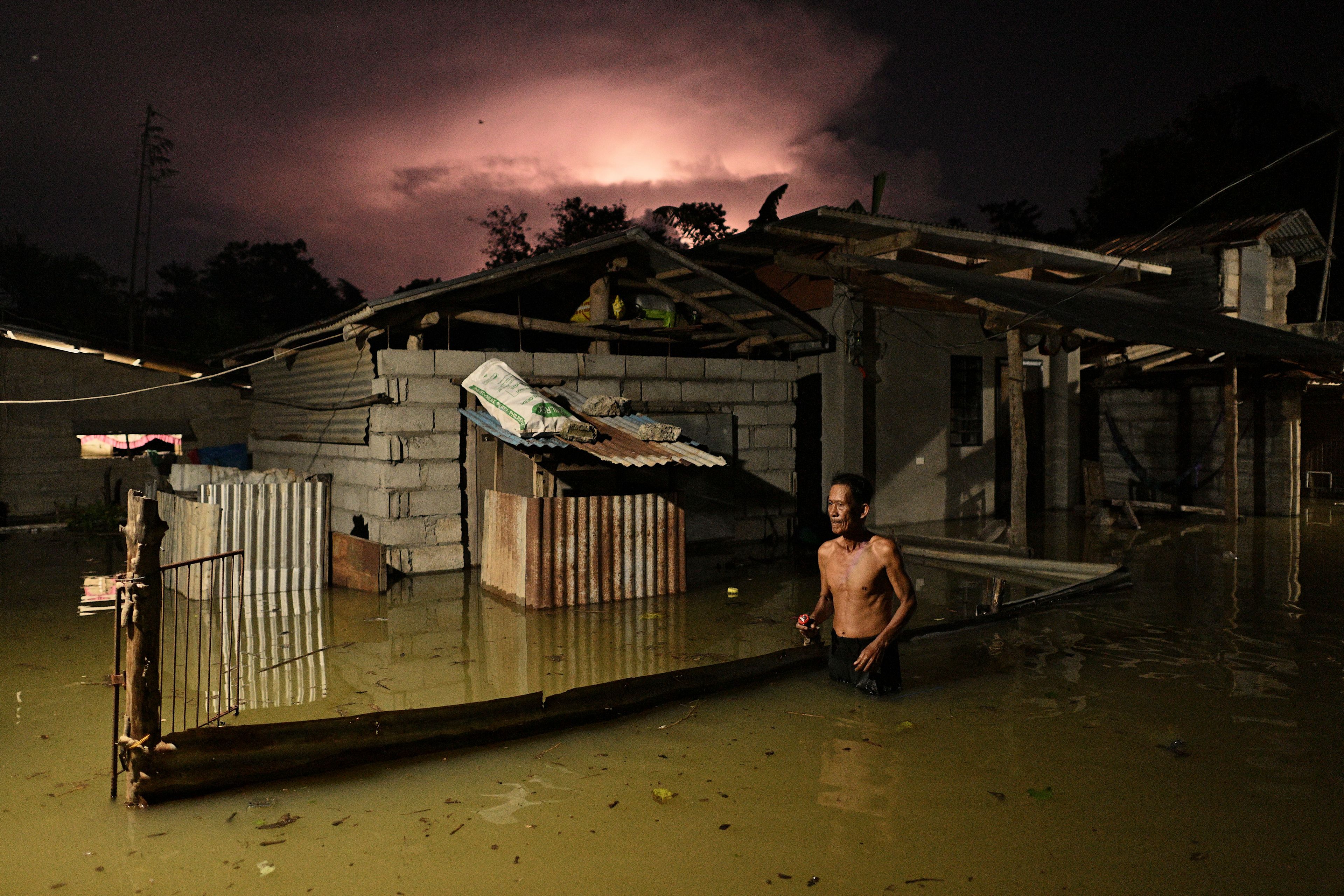 A resident wades through a flooded street caused by heavy rains from typhoon Toraji in Ilagan City, Isabela province, northern Philippines on Tuesday, Nov. 12, 2024. (AP Photo/Noel Celis)