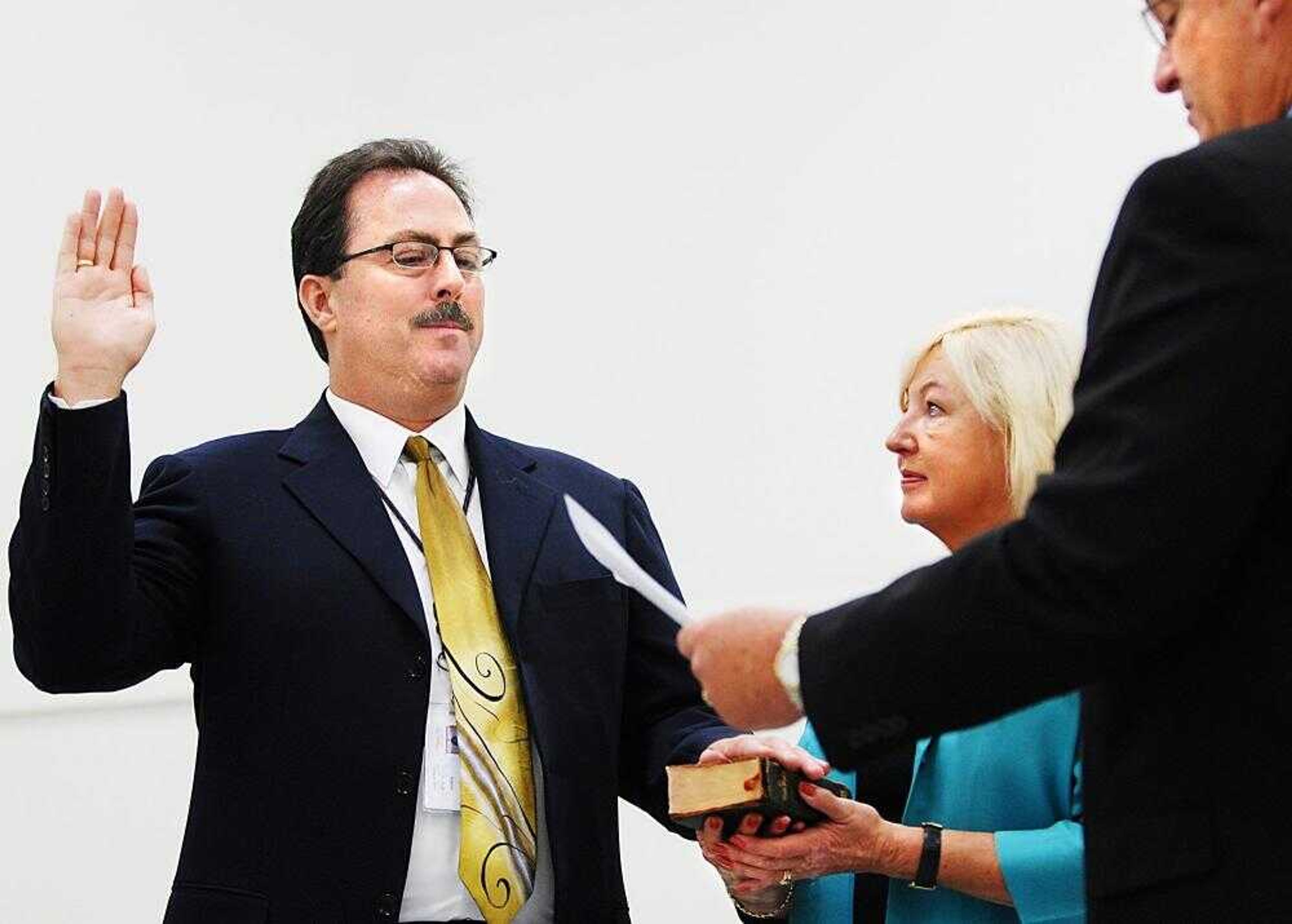 Robert Fleming was sworn in Friday as the 31st postmaster in Cape Girardeau by Mid-America District senior manager Jarman Smith as Fleming's wife, Pam, held the Bible during an installation ceremony at the Richard G. Wilson Processing and Distribution Facility. (Aaron Eisenhauer)