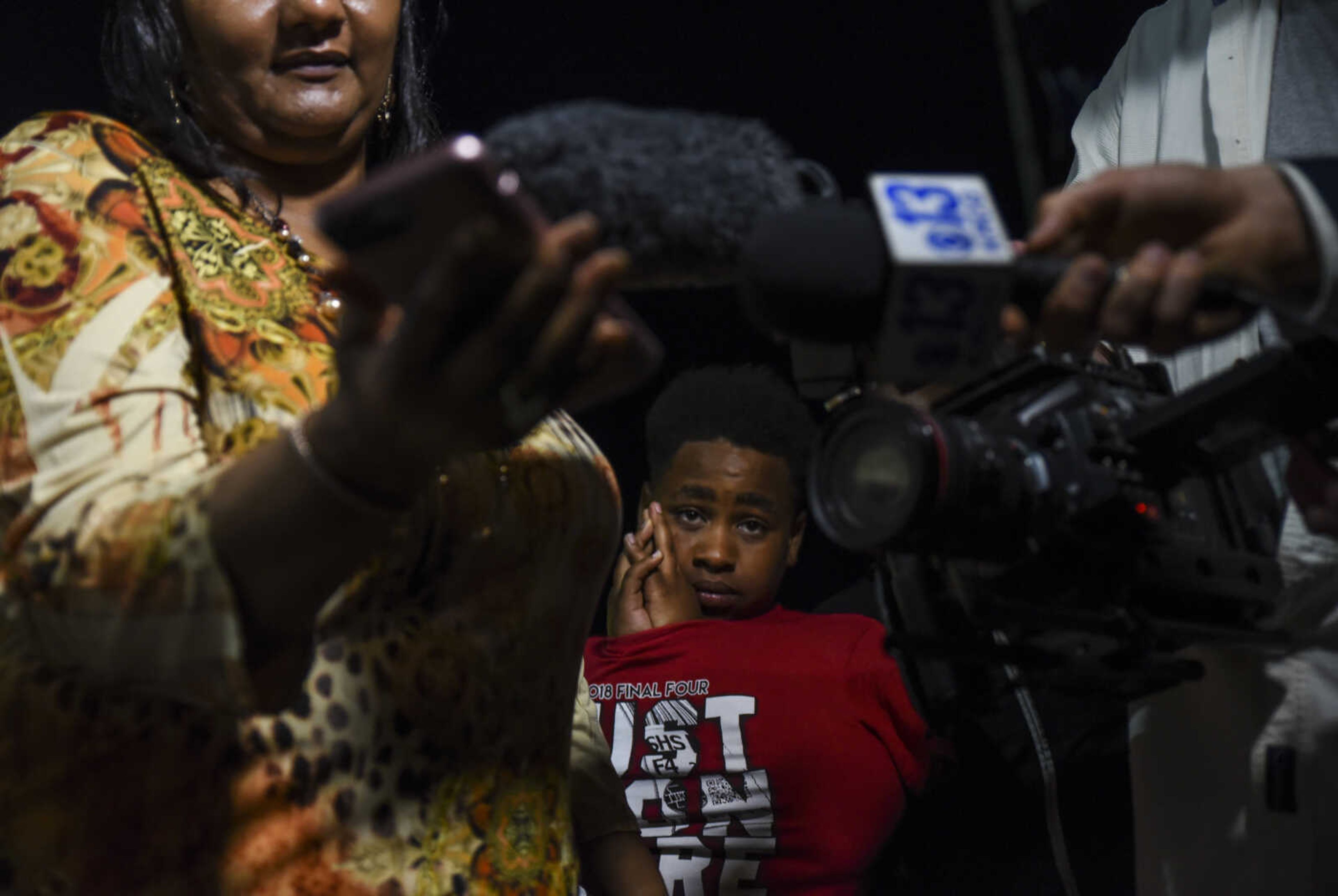 Maliek Patterson, center, listens to David Robinson answer questions on his thoughts and feelings of the confusing situation outside of the Jefferson City Correctional Center Monday, May 14, 2018 in Jefferson City.