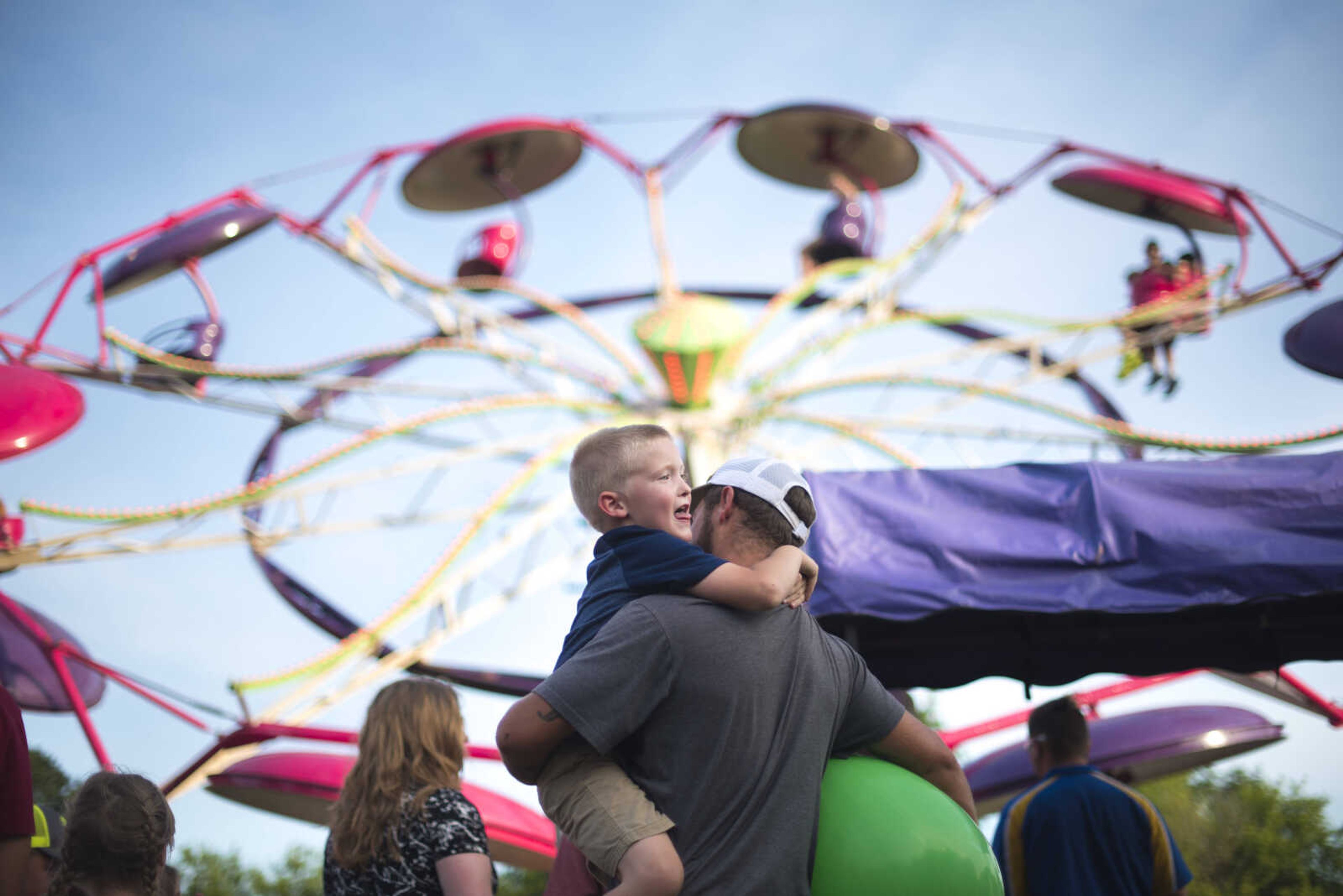 Dustin Mcelhaney and his son Braedyn Mcelhaney, 6, wait in line for a ride during the 41st annual Mid-Summer Festival Saturday, June 17, 2017 at Scott City Park.