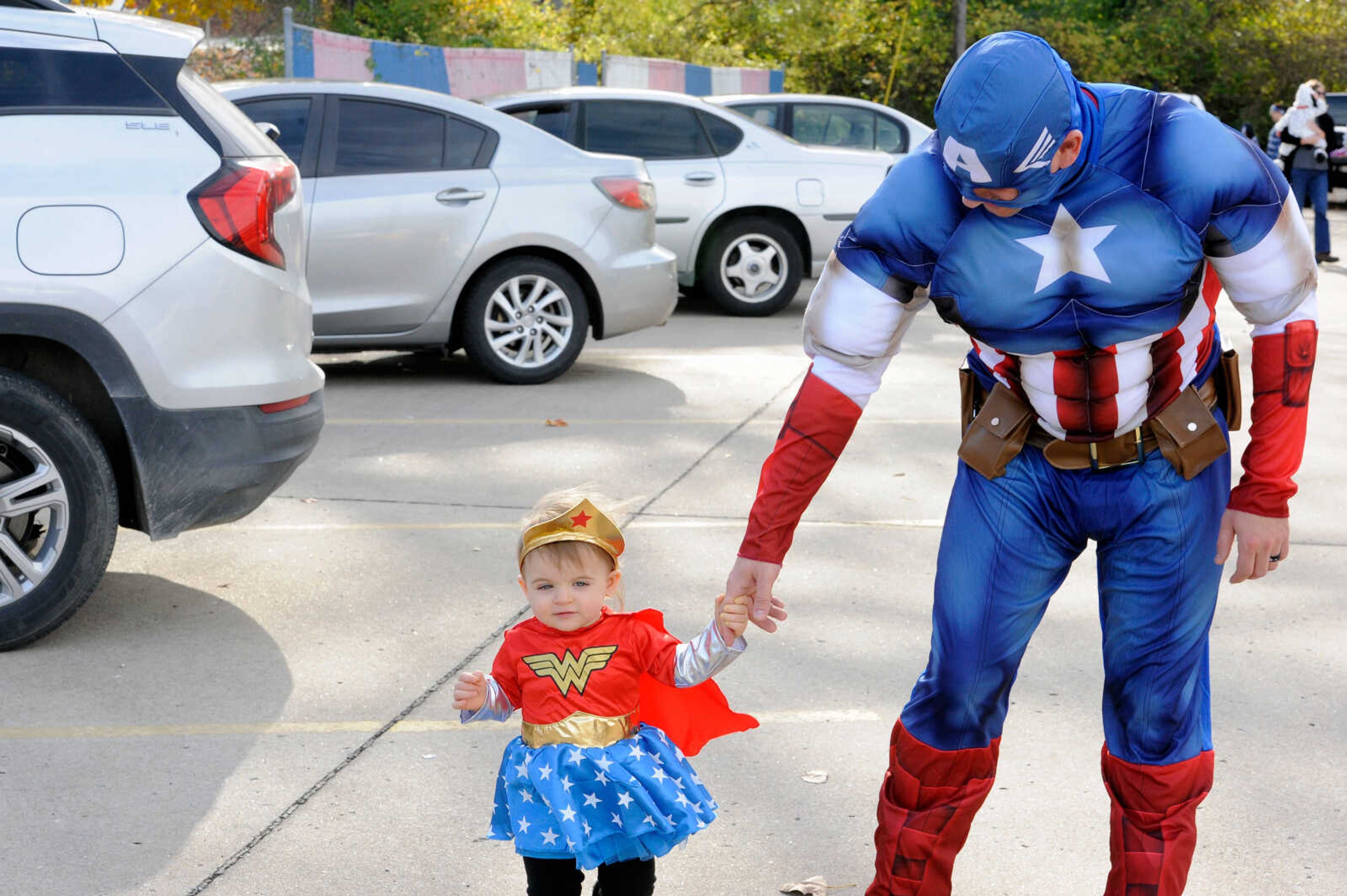 Sean Davis (RIGHT) holds hands with his daughter, Charlotte, while walking at the VFW's trunk or treaet event on Halloween 2020 at the Cape Girardeau VFW Post No. 3838. Many organizations are hosting Halloween-related events this week.