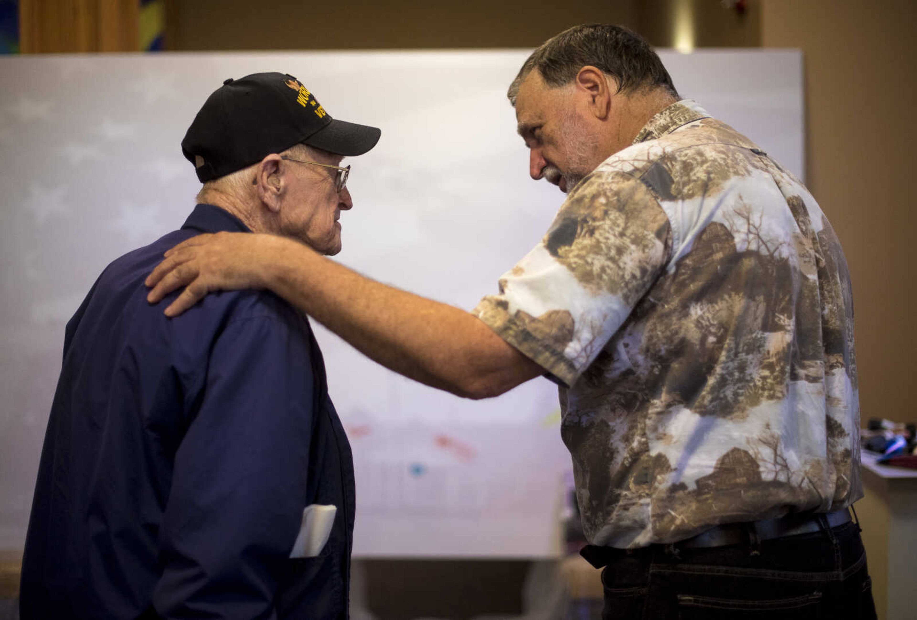 Aaron Horrell, right, places his hand on the shoulder of Robert Duckworth, left, after he helped contribute paint for Paint-For-A-Cause where the residents of the Missouri Veterans Home will be given the opportunity to paint first on the big image Friday, July 28, 2017 in Cape Girardeau. Aaron Horrell will then take the painting to the SEMO District Fair where people can also help paint to raise money for the home.