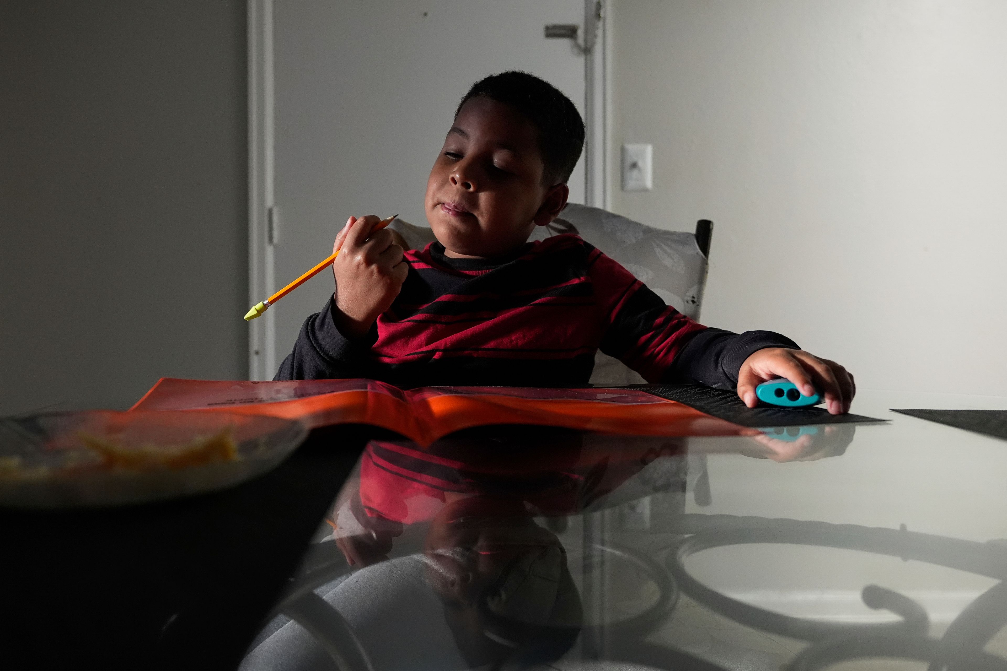 Dylan Martínez-Ramírez sharpens his pencil before heading to school Thursday, Aug. 29, 2024, in Aurora, Colo. (AP Photo/Godofredo A. Vásquez)