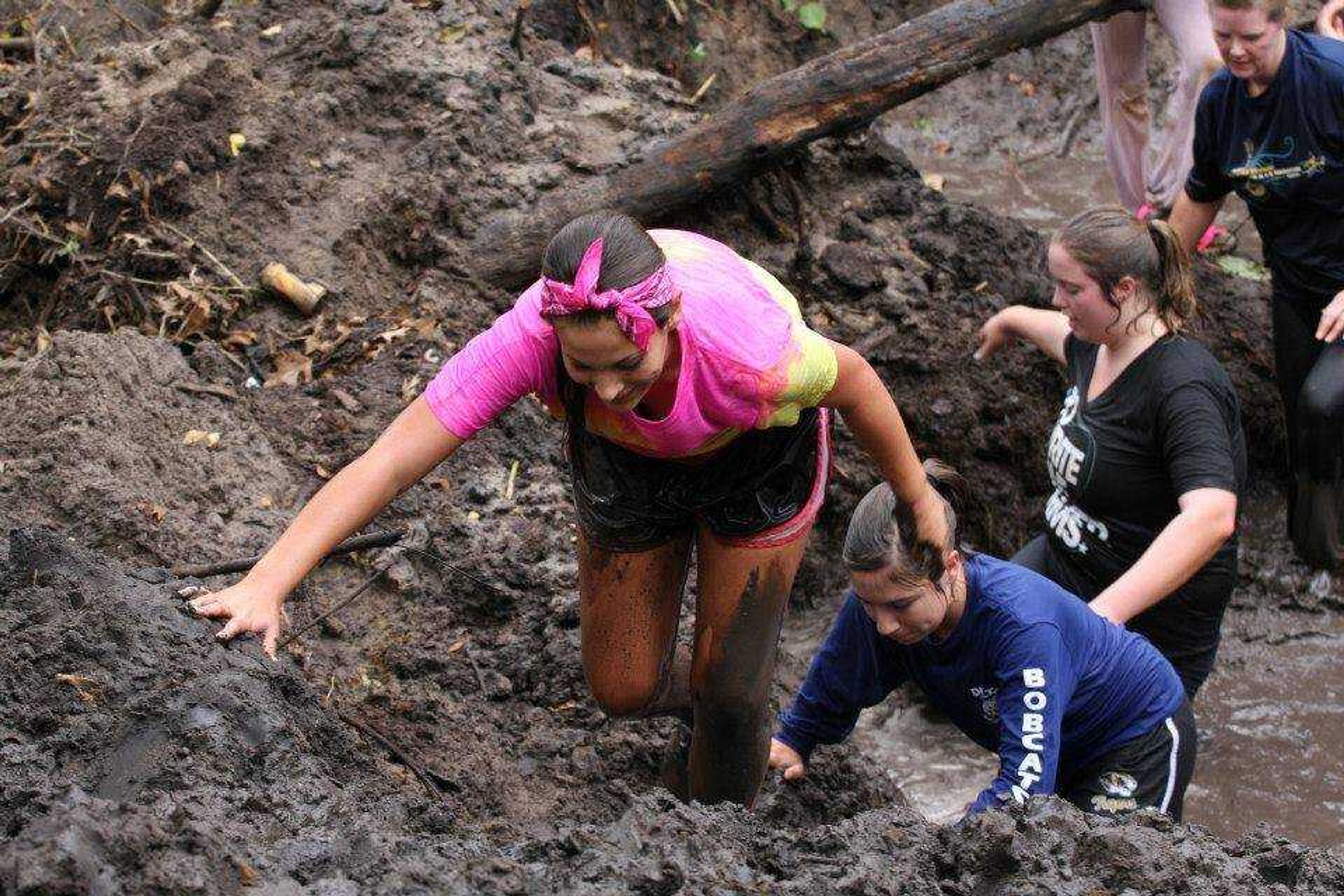 Danielle Newman, Danielle Helderman, Amy Featherston, and Robin Featherston crossing one of the mud pits on the BackWoods Beat-Down course.