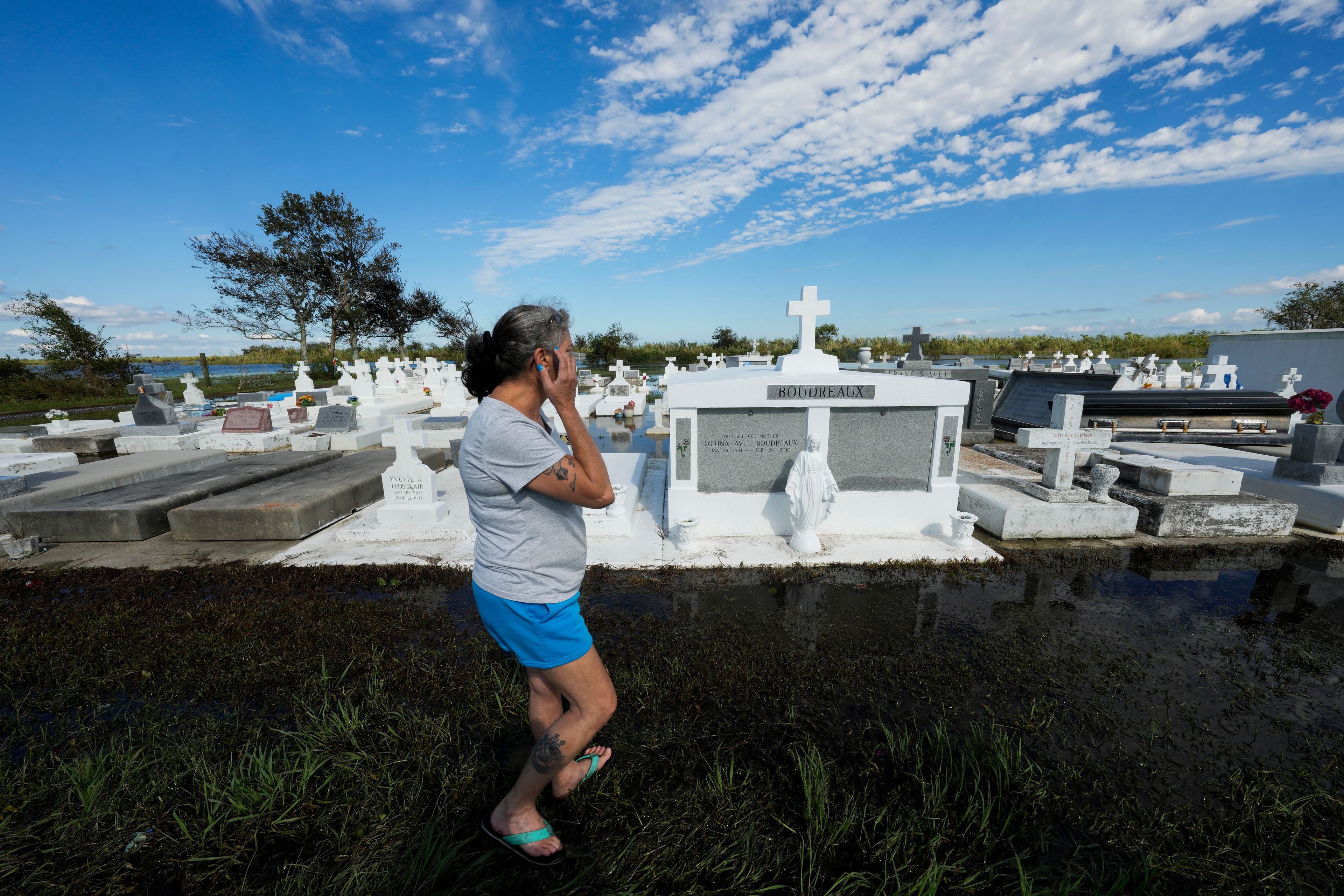 Lori-Ann Bergeron checks on the graves of her sister and mother to see that they were not disturbed by flooding, in the aftermath of Hurricane Francine, in Dulac, La., Thursday, Sept. 12, 2024. (AP Photo/Gerald Herbert)