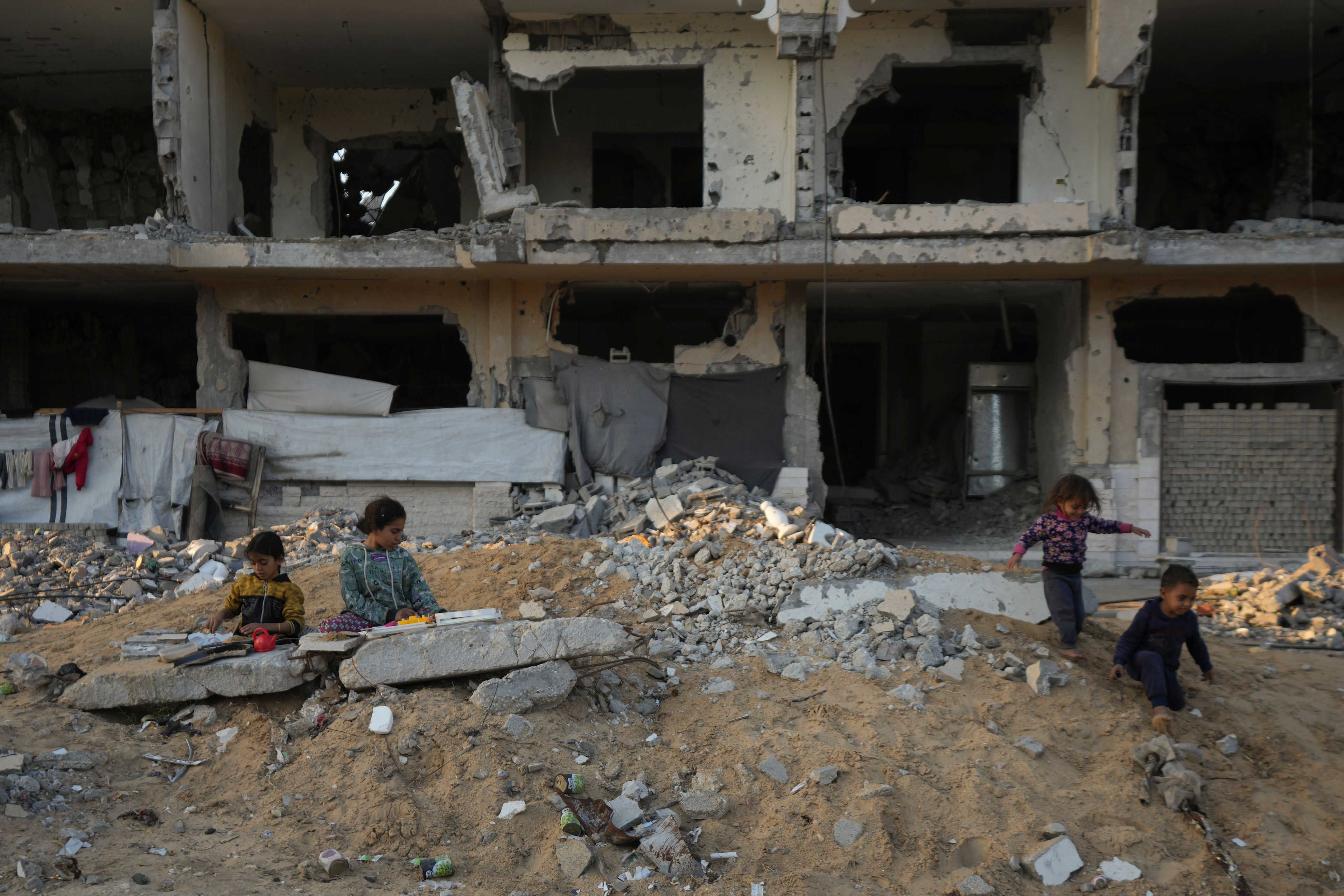 Palestinian children play on the rubble of destroyed buildings at a neighbourhood in Khan Younis, Gaza Strip, Sunday, Dec. 1, 2024. (AP Photo/Abdel Kareem Hana)