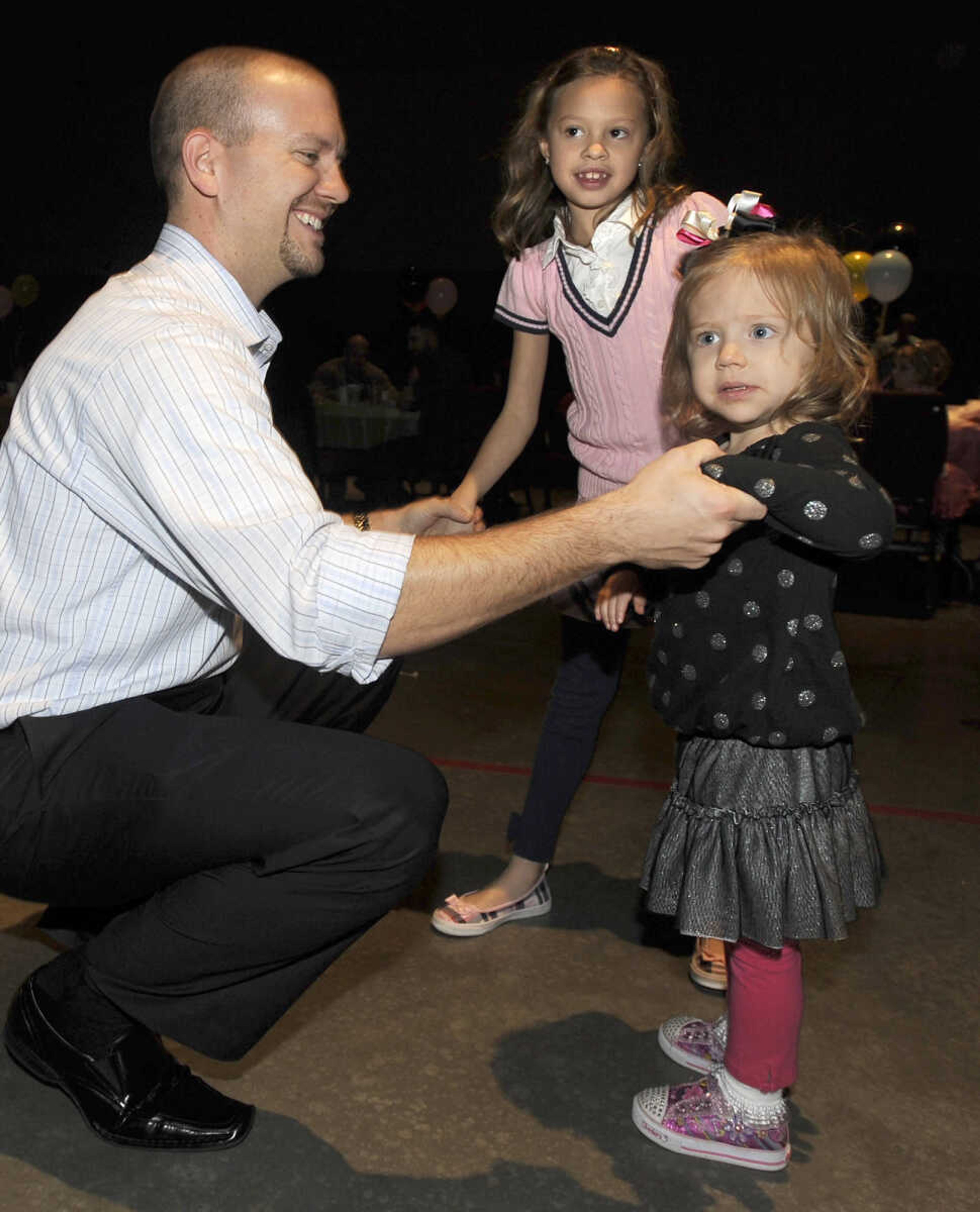 Josh Lukefahr shares a dance with his daughters, Katie, right, and Mackenzie at the Me and My Guy Dance.