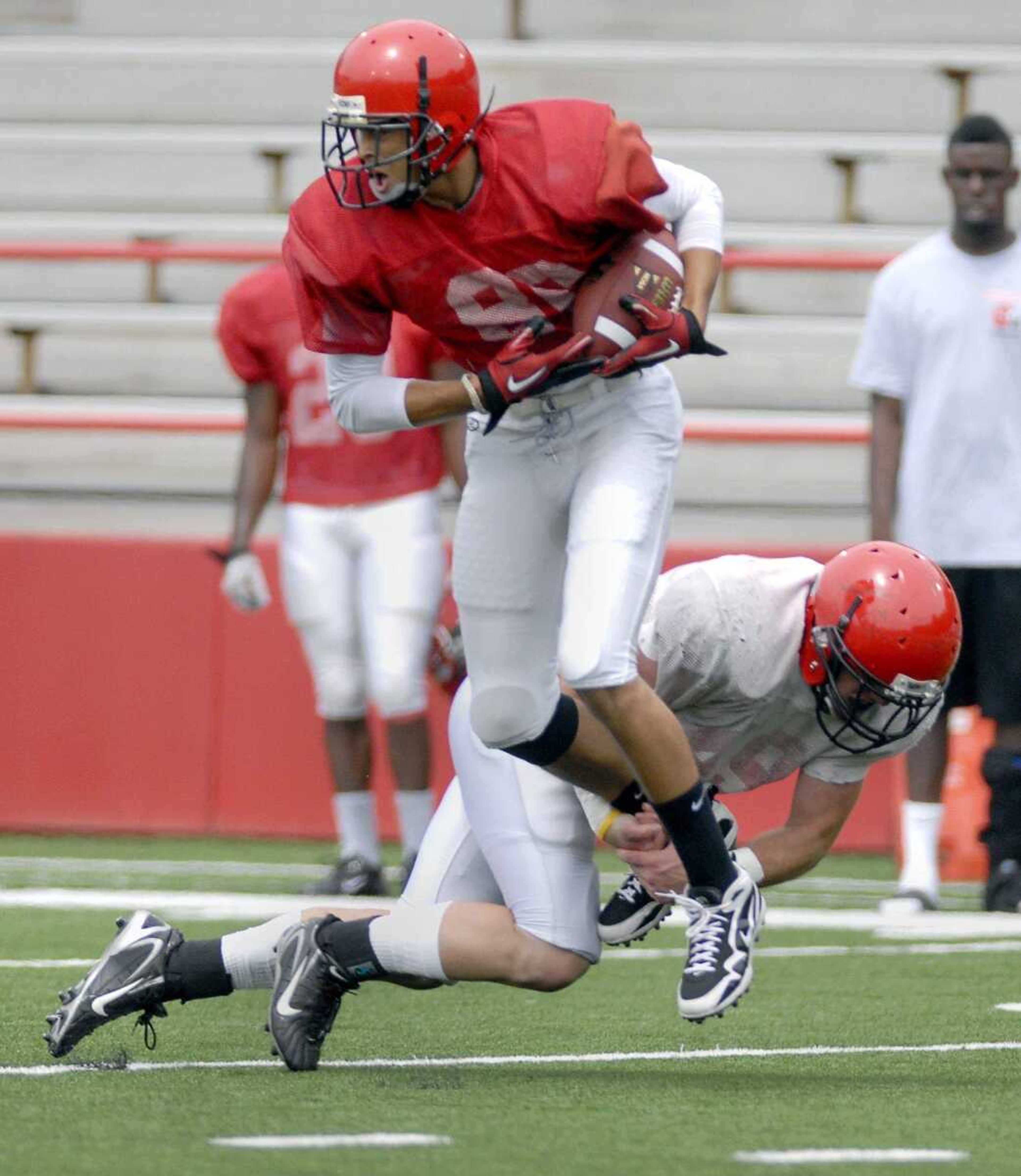 Southeast Missouri State University defender Daniel Siehndel tries to bring down receiver D.J. Foster during the Redhawks' scrimmage at Houck Stadium.