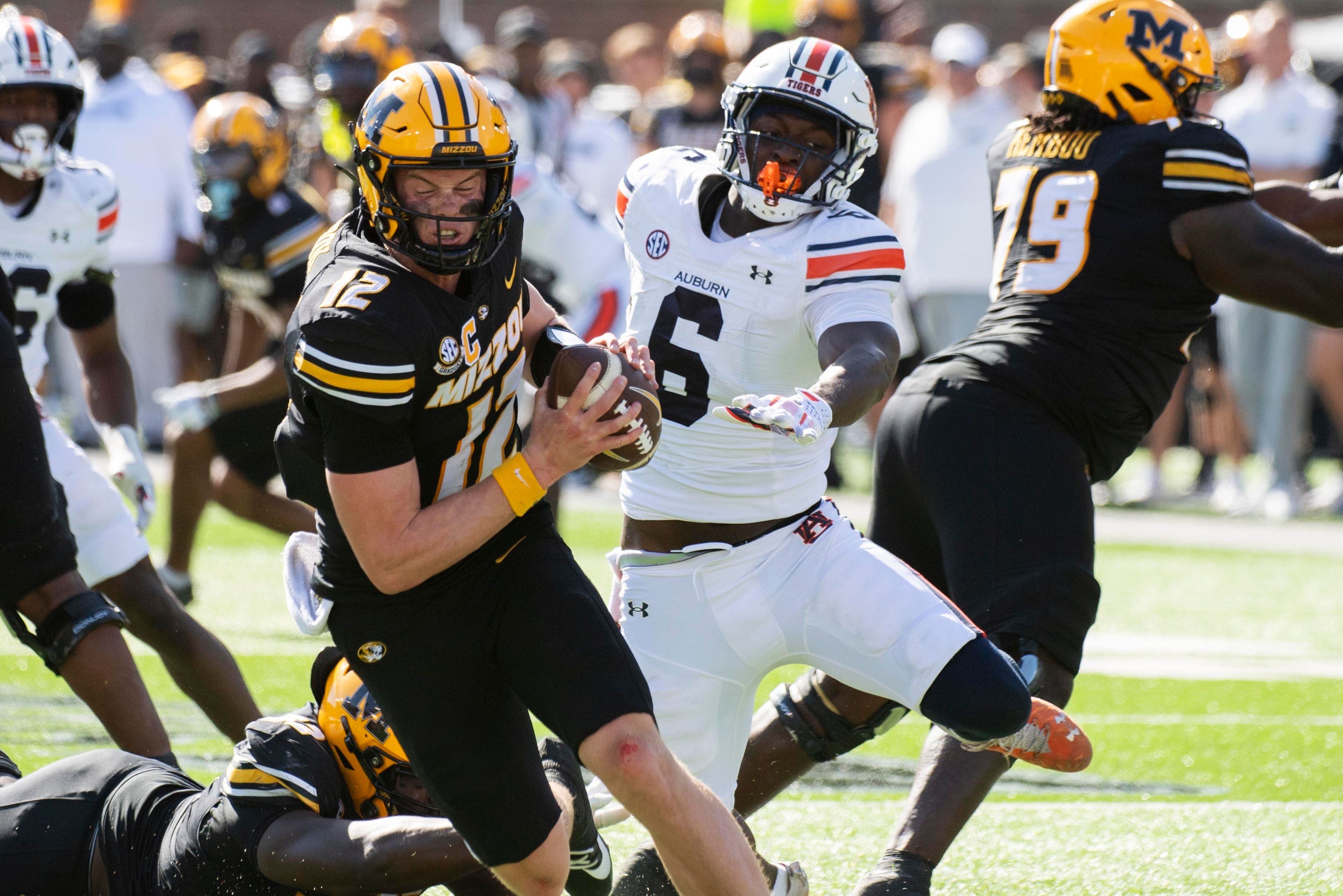 Missouri quarterback Brady Cook, left, spins away from Auburn linebacker Austin Keys during the second half of an NCAA college football game Saturday, Oct. 19, 2024, in Columbia, Mo. Missouri won 21-17. (AP Photo/L.G. Patterson)