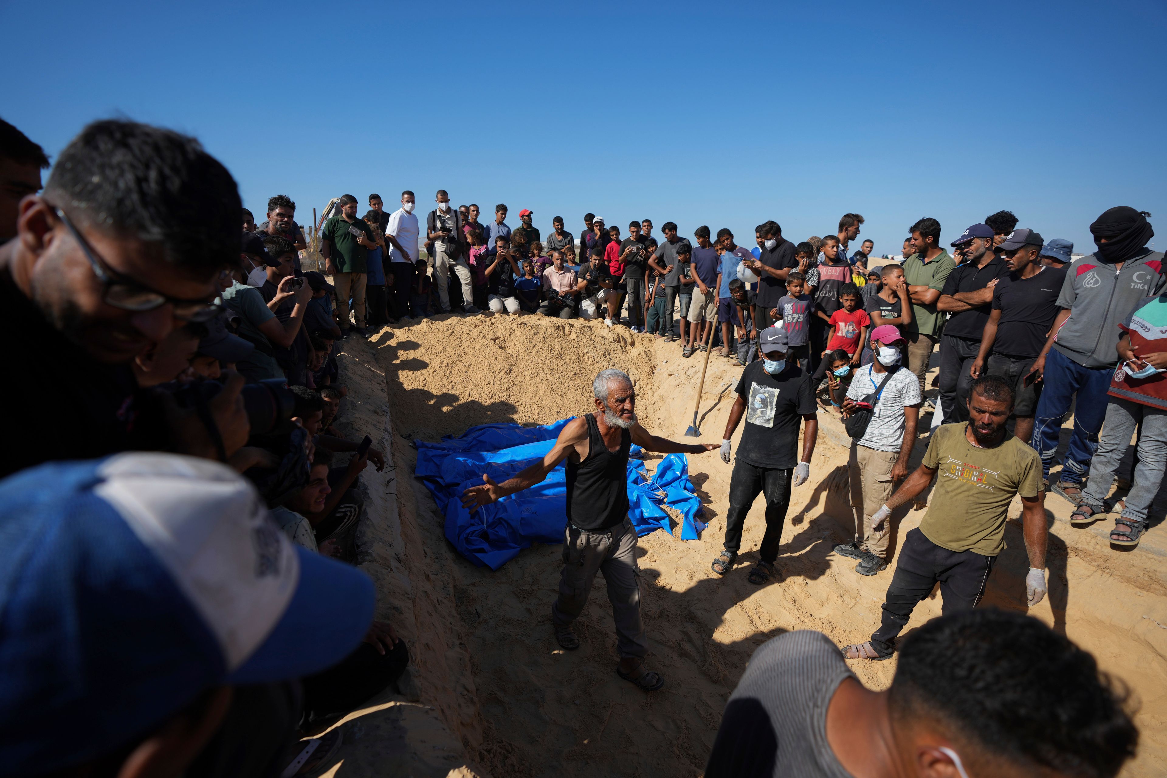 People bury the bodies of Palestinians taken by the Israeli military during operations in Gaza and returned this week, in Khan Younis, Gaza Strip, Thursday, Sept. 26, 2024. (AP Photo/Abdel Kareem Hana)