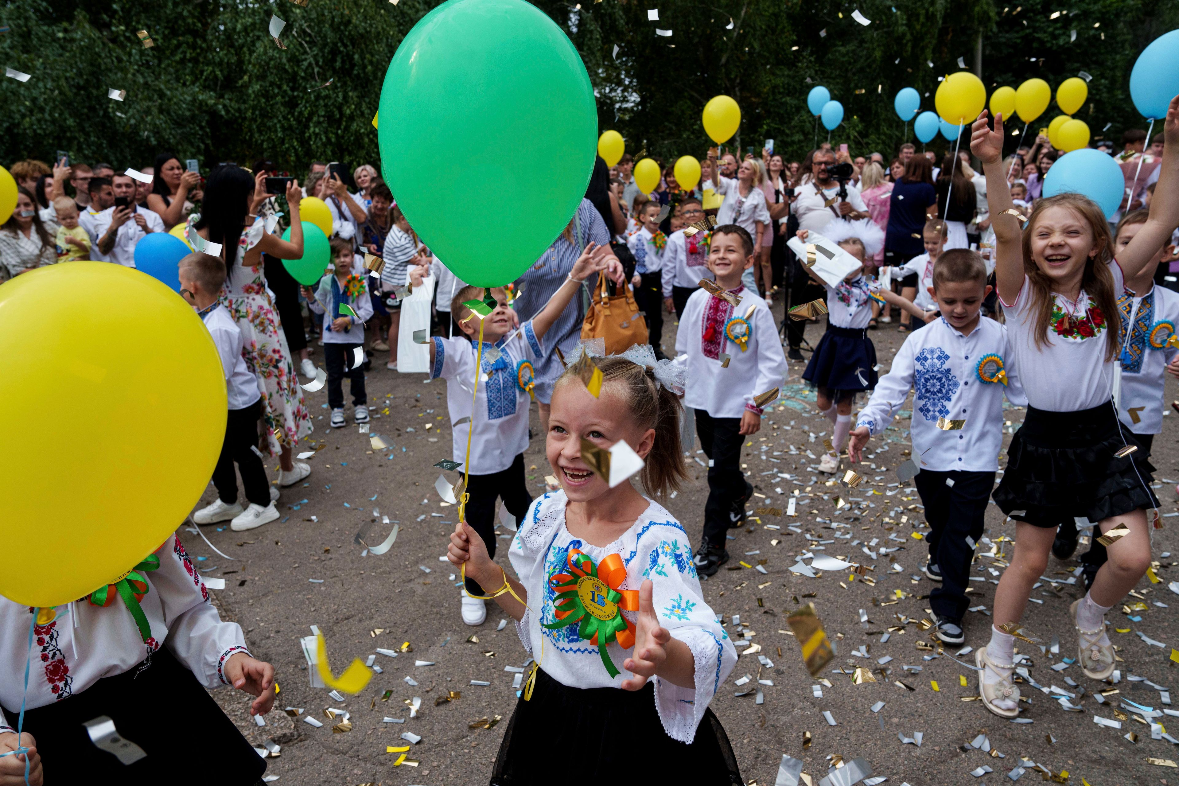 First-graders at Gymnasium No. 6 attend a traditional back-to-school ceremony in Zaporizhzhia, Ukraine, Sept. 1, 2024. (AP Photo/Evgeniy Maloletka)