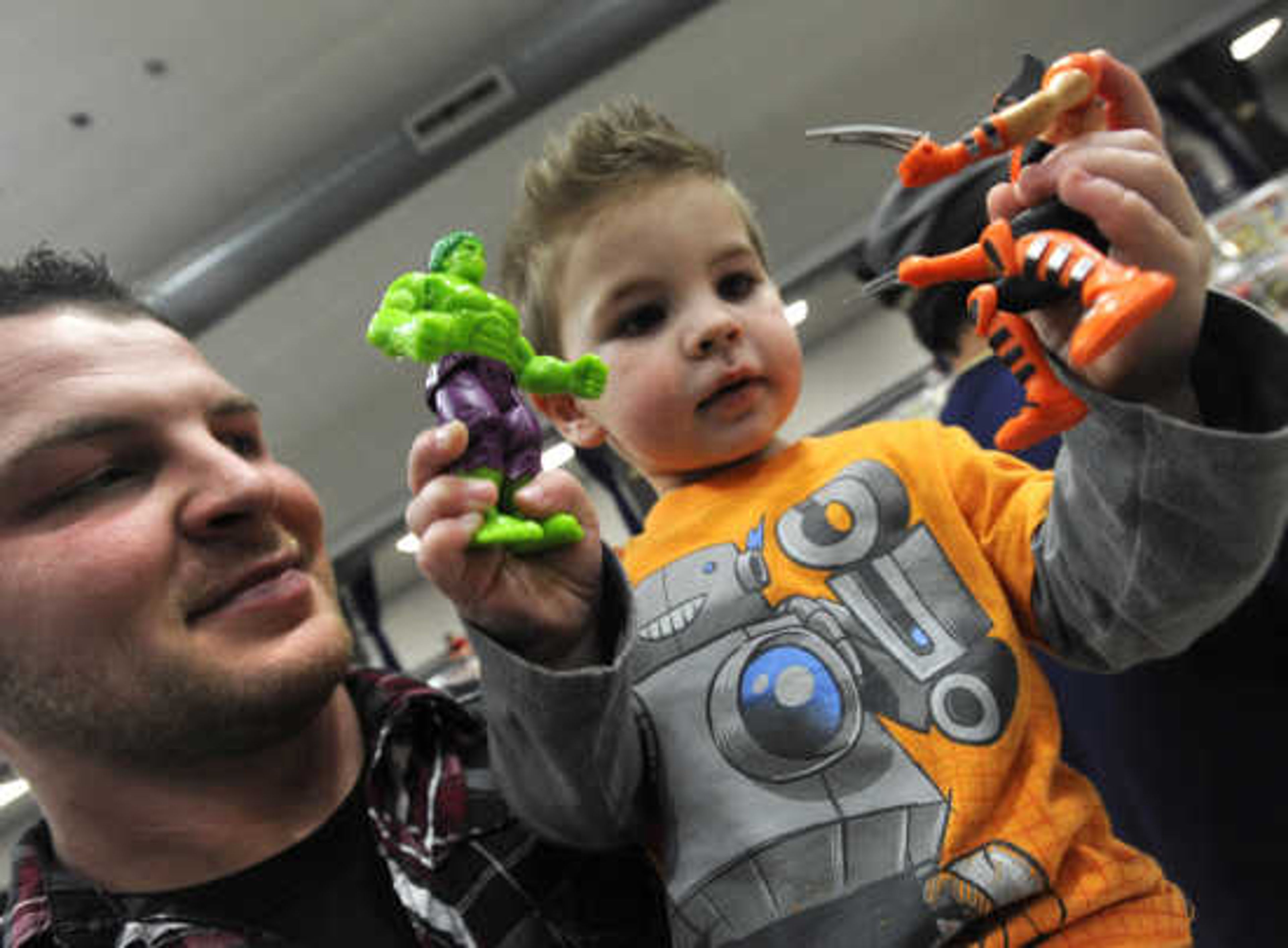 Joe Givens and his son, Brody, of Sikeston play with comic-book figures at Cape Comic Con on Saturday, March 22, 2014, at the Arena Building.