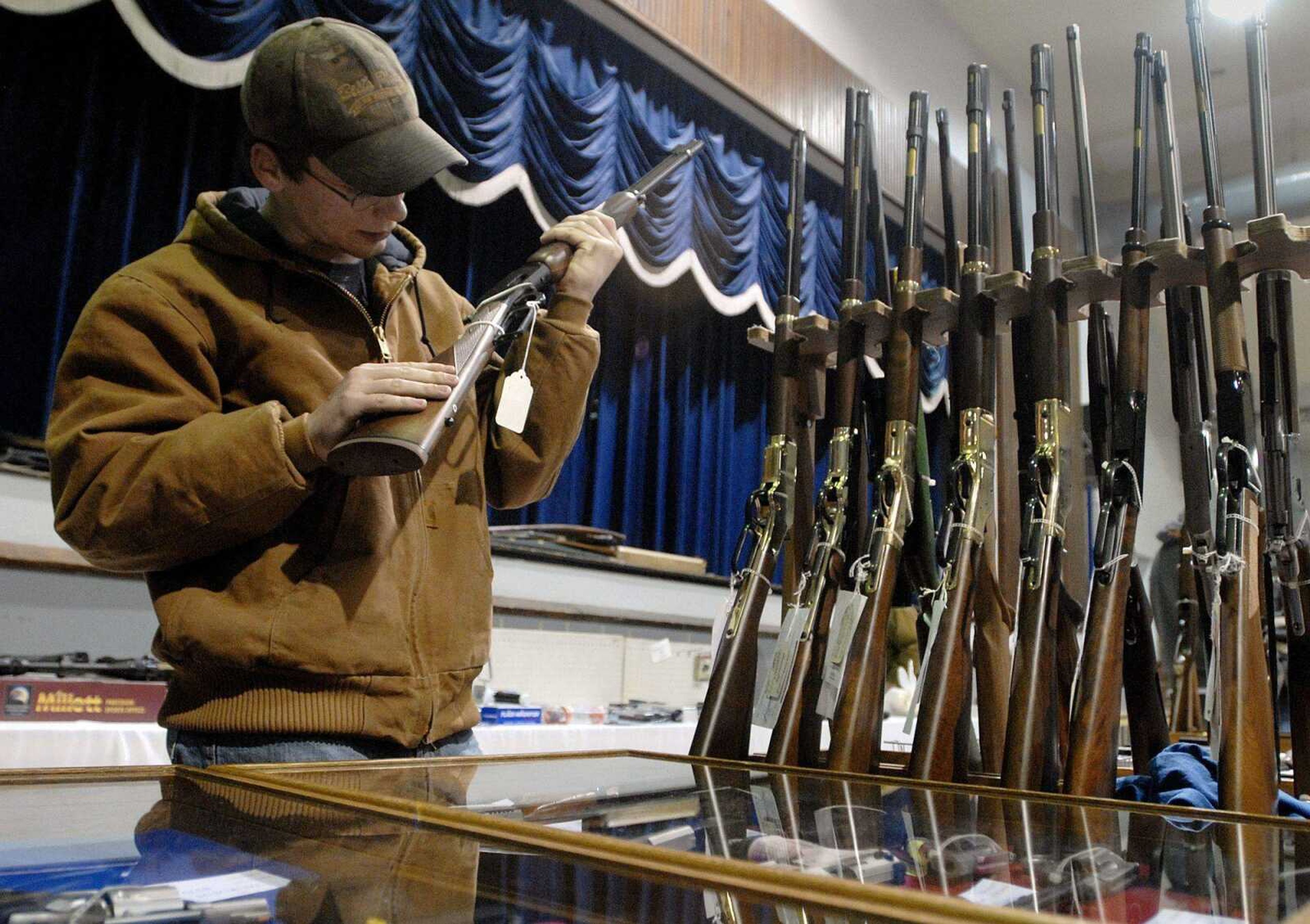 Ethan Siemer looks over a .44 magnum rifle at Norm's Guns Inc. booth Sunday during the SEMO Gun Show at the Arena Building in Cape Girardeau. Siemer said he was going to buy the gun because he hunts quite a bit. (Laura Simon)