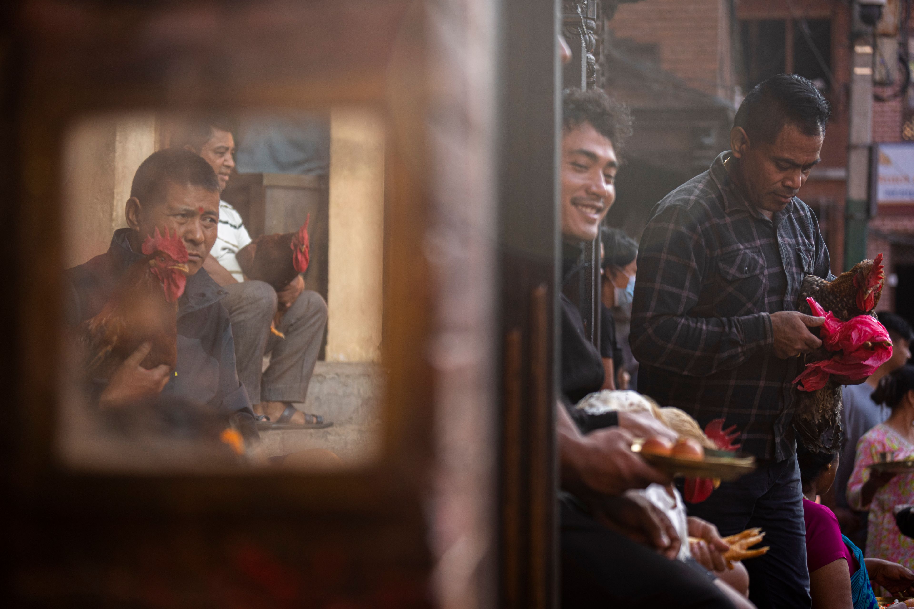 Devotees wait with sacrificial chickens as they prepare to enter Balkumari Temple during Dashain festival in Thimi, Bhaktapur, Nepal, Friday, Oct. 11, 2024. The festival commemorates the slaying of a demon king by Hindu goddess Durga, marking the victory of good over evil. (AP Photo/Niranjan Shrestha)