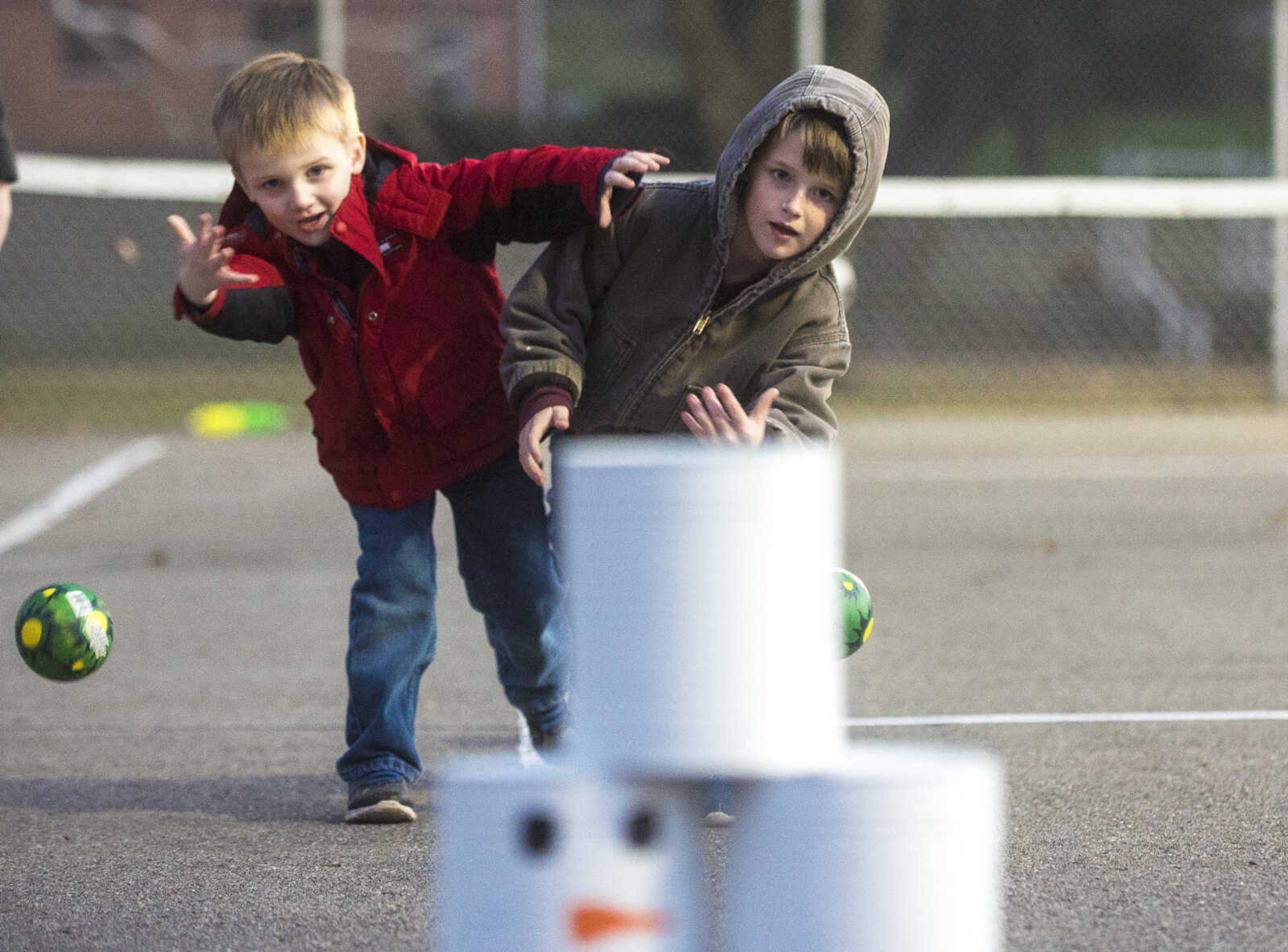 Trevor Ardry, 4, left, and his brother Kaiden Ardry, 6, throws balls at snowman cans during the Jackson Holiday Extravaganza Friday, Nov. 24, 2017 at the Jackson City Park.