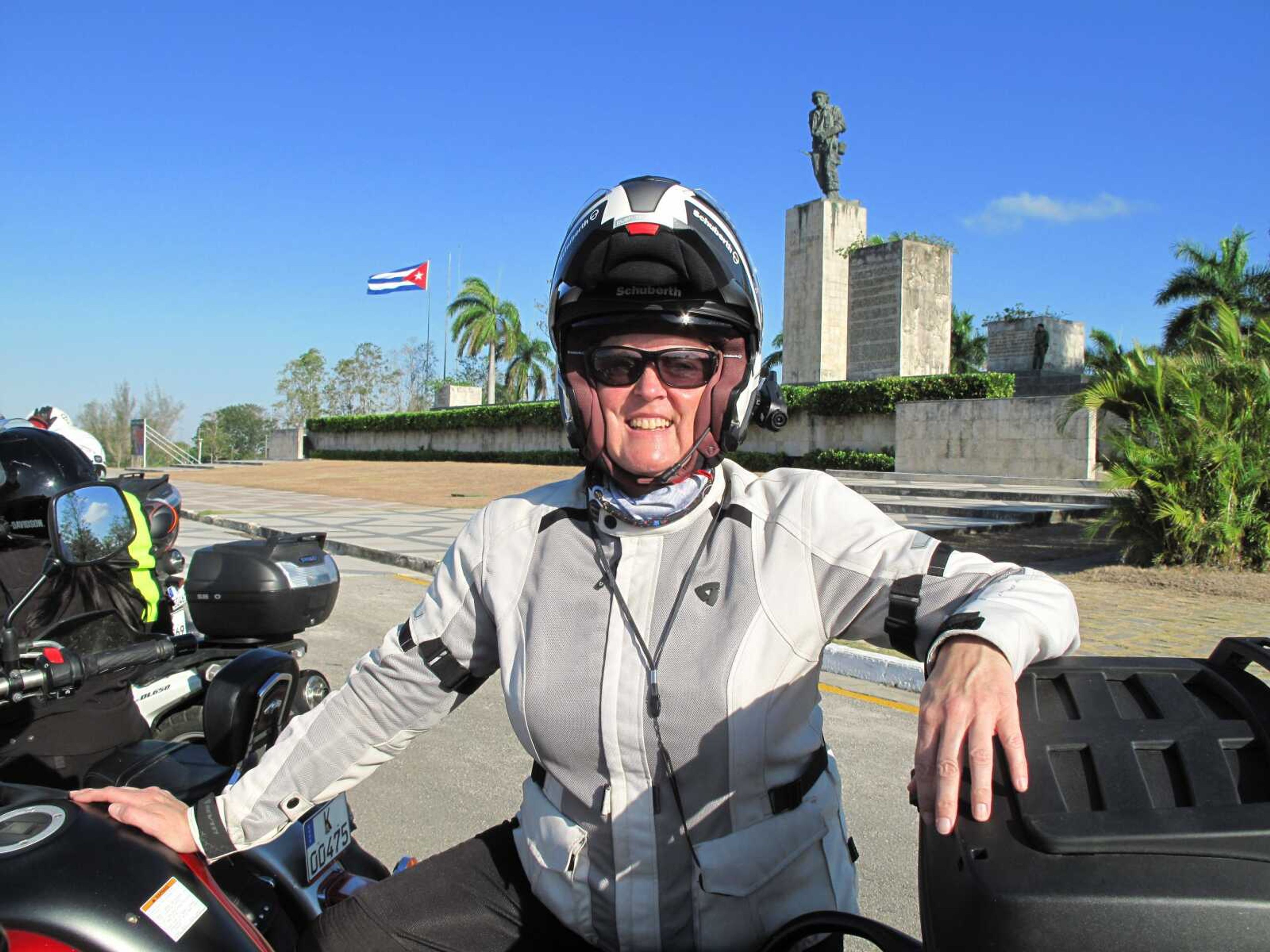 This March 2017 photo provided by Alisa Clickenger, shows Clickenger posing in front of the Che Guevara Mausoleum, a favored stop for visitors in Cuba. Clickenger operates Women's Motorcycle Tours, which conducts motorcycle rides that cater exclusively to women, and estimates she's traveled more than 250,000 miles on motorcycles. (Courtesy of Alisa Clickenger via AP)