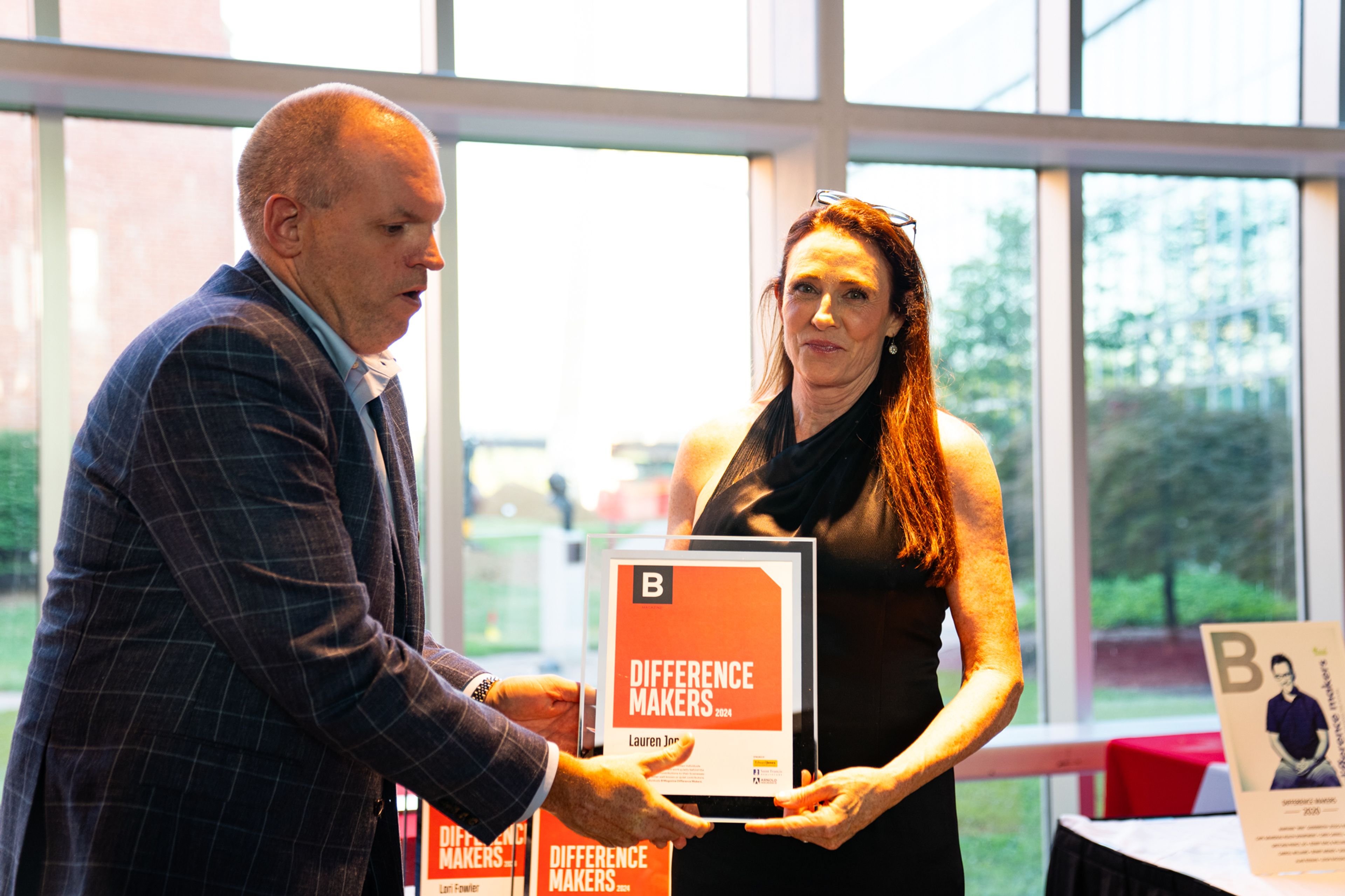 Lauren Jones receives a plaque from Saint Francis Healthcare System’s Matthew Brandt recognizing her as a 2024 Difference Maker at their reception at Southeast Missouri State University’s River Campus. The Difference Maker’s reception was presented by B Magazine on Thursday, Sept. 6.