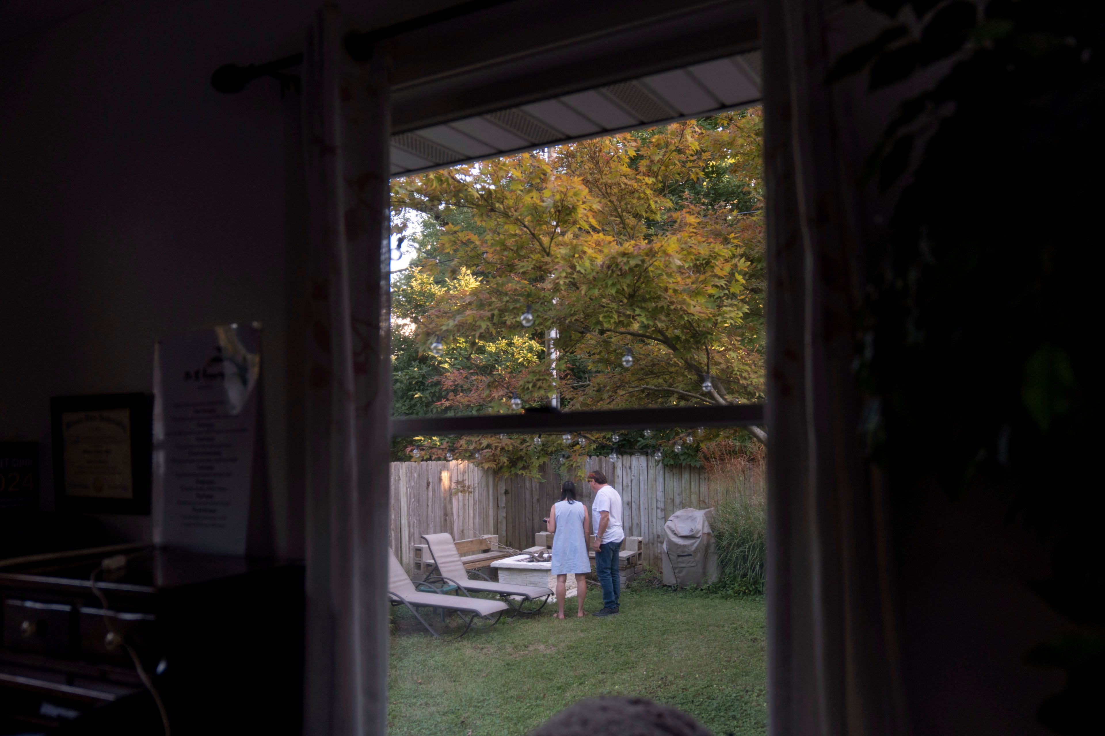 Lesley, left, and Matt Dzik, stand in their backyard in Champaign, Ill., Friday, Sept. 20, 2024. When they started dating, all it took was the sight of Democratic lawn signs outside his house ahead of the 2020 election to make her question if their relationship could work. (AP Photo/David Goldman)