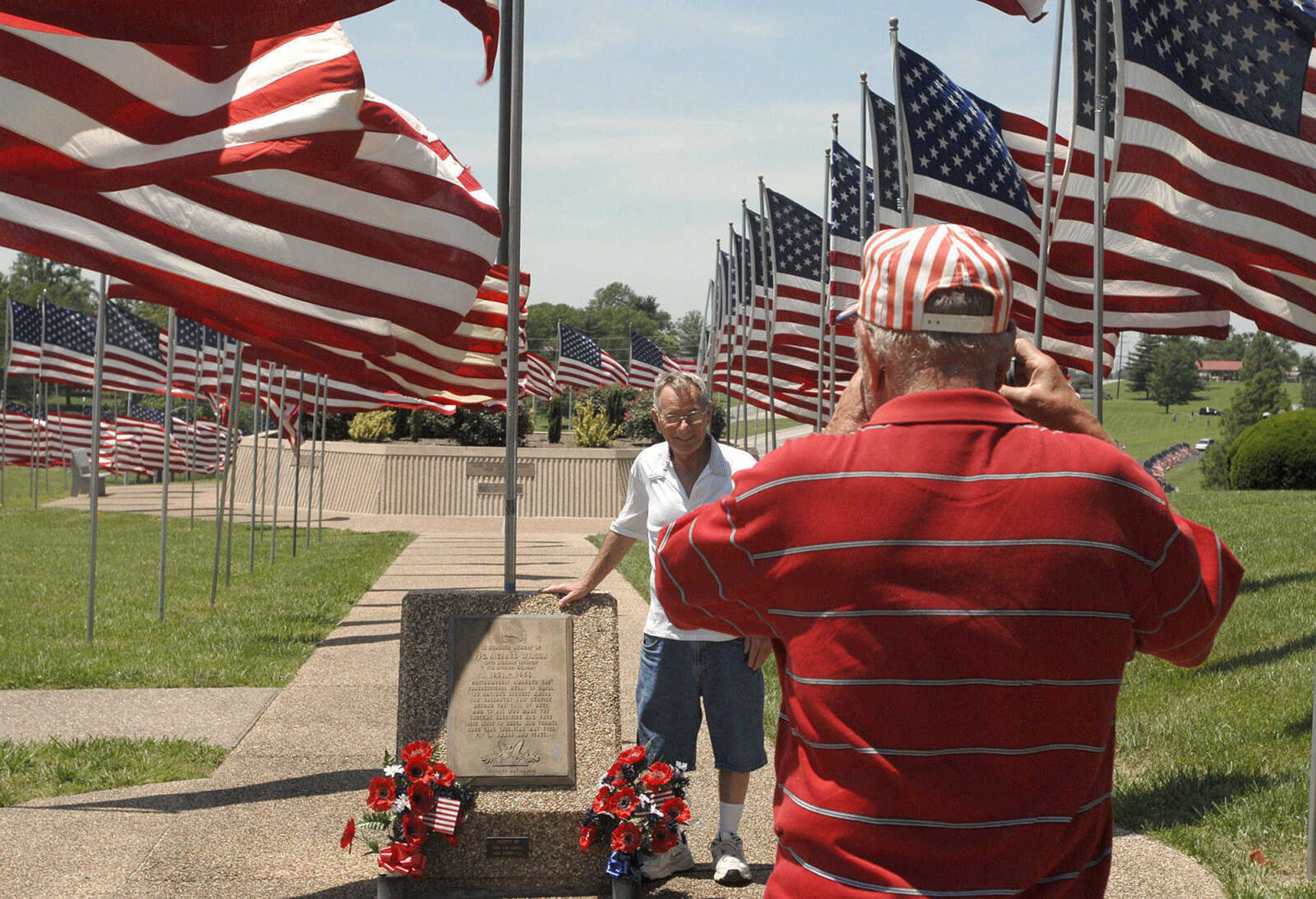 LAURA SIMON~lsimon@semissourian.com
Korean War veteran Bob Seabaugh takes a photo of Vietnam War veteran Dennis Mills at the Avenue of Flags Monday, May 30, 2011 at Cape County Park.