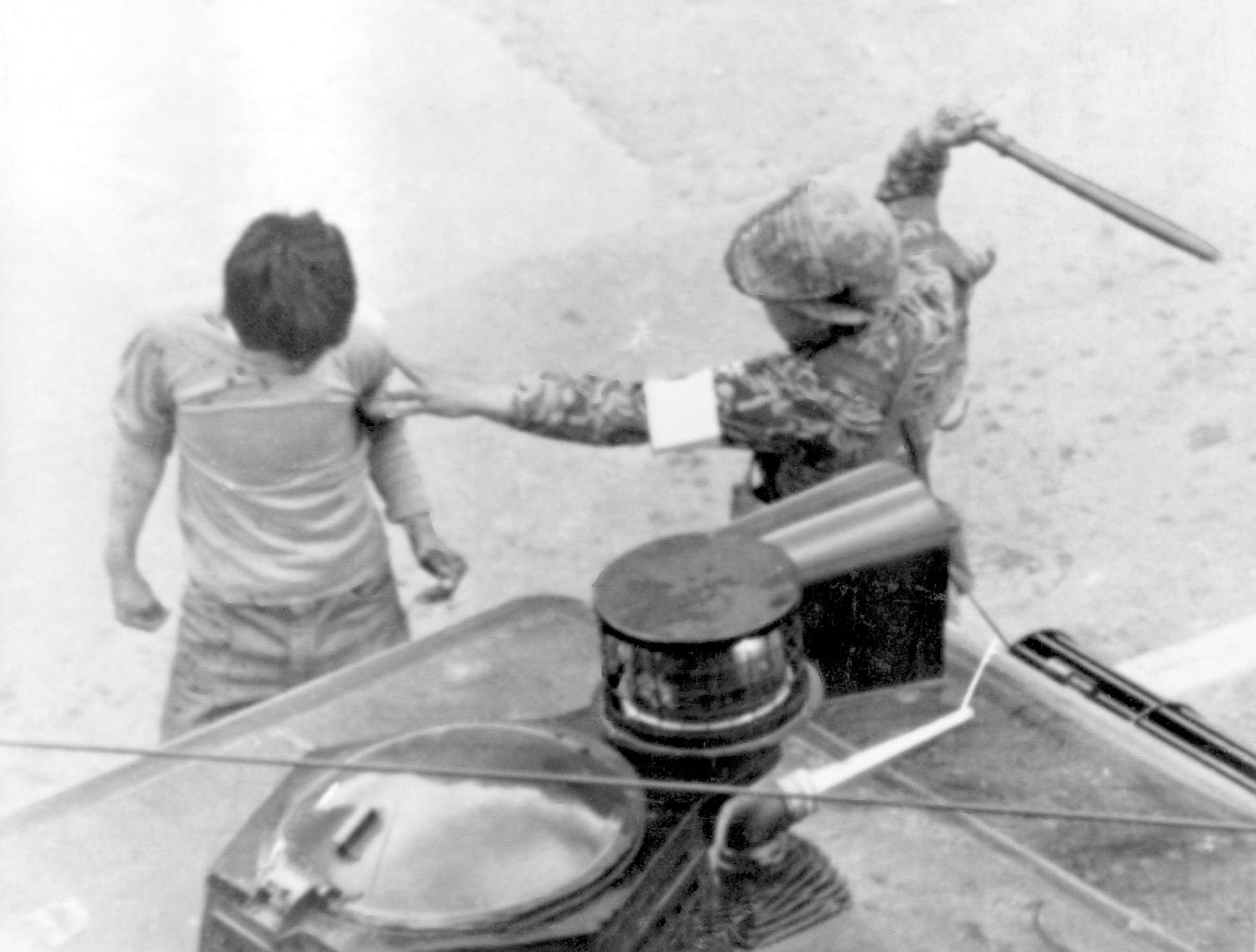 FILE- A helmeted army paratroops beats a man arrested during violent anti-government demonstrations in Gwangju (Kwangju), May 20, 1980. (AP Photo/File)