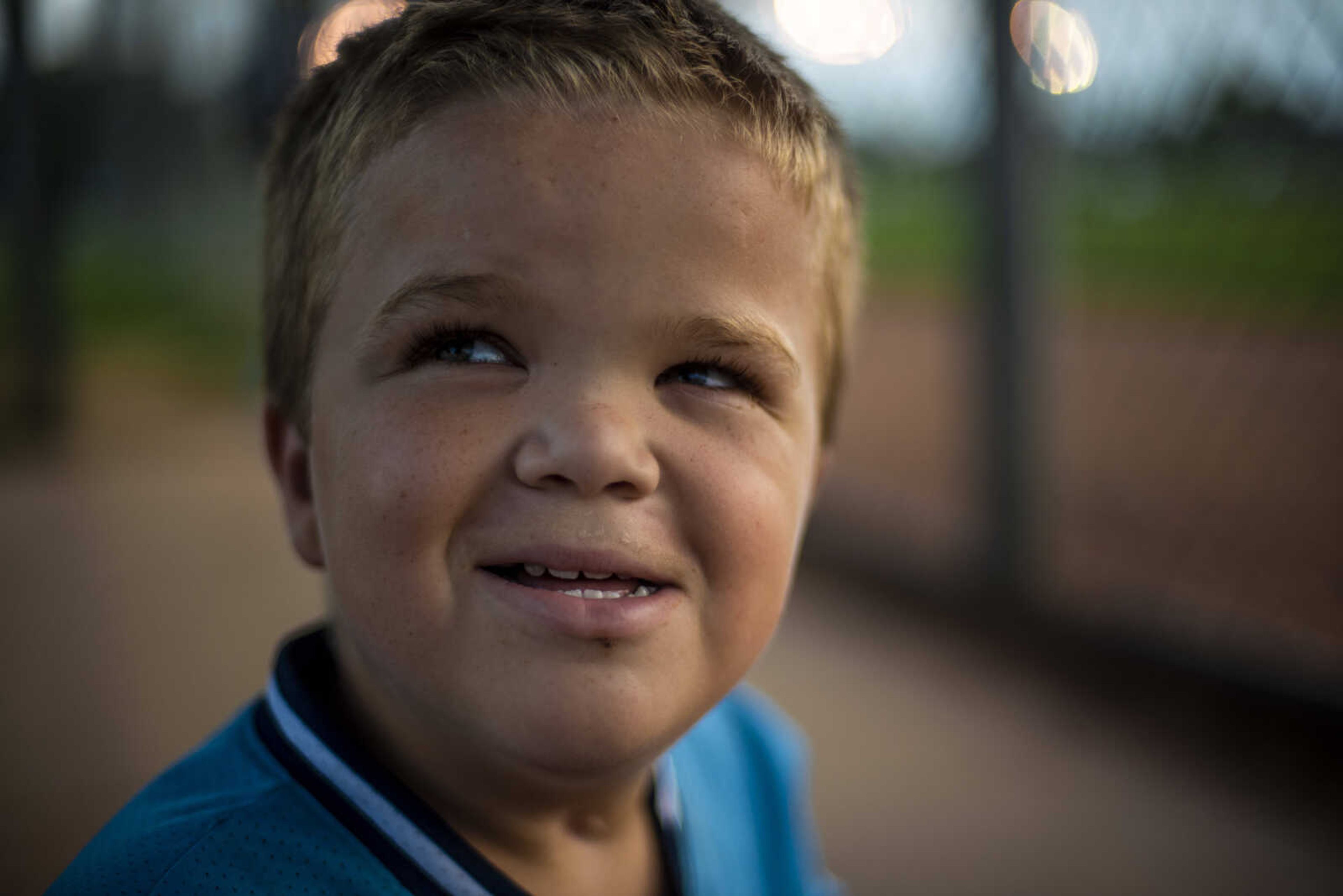 Izaac Pursley smiles at a friend while sitting in the dugout during a recreational softball game Aug. 30, 2018, at the Shawnee Park Sports Complex in Cape Girardeau.