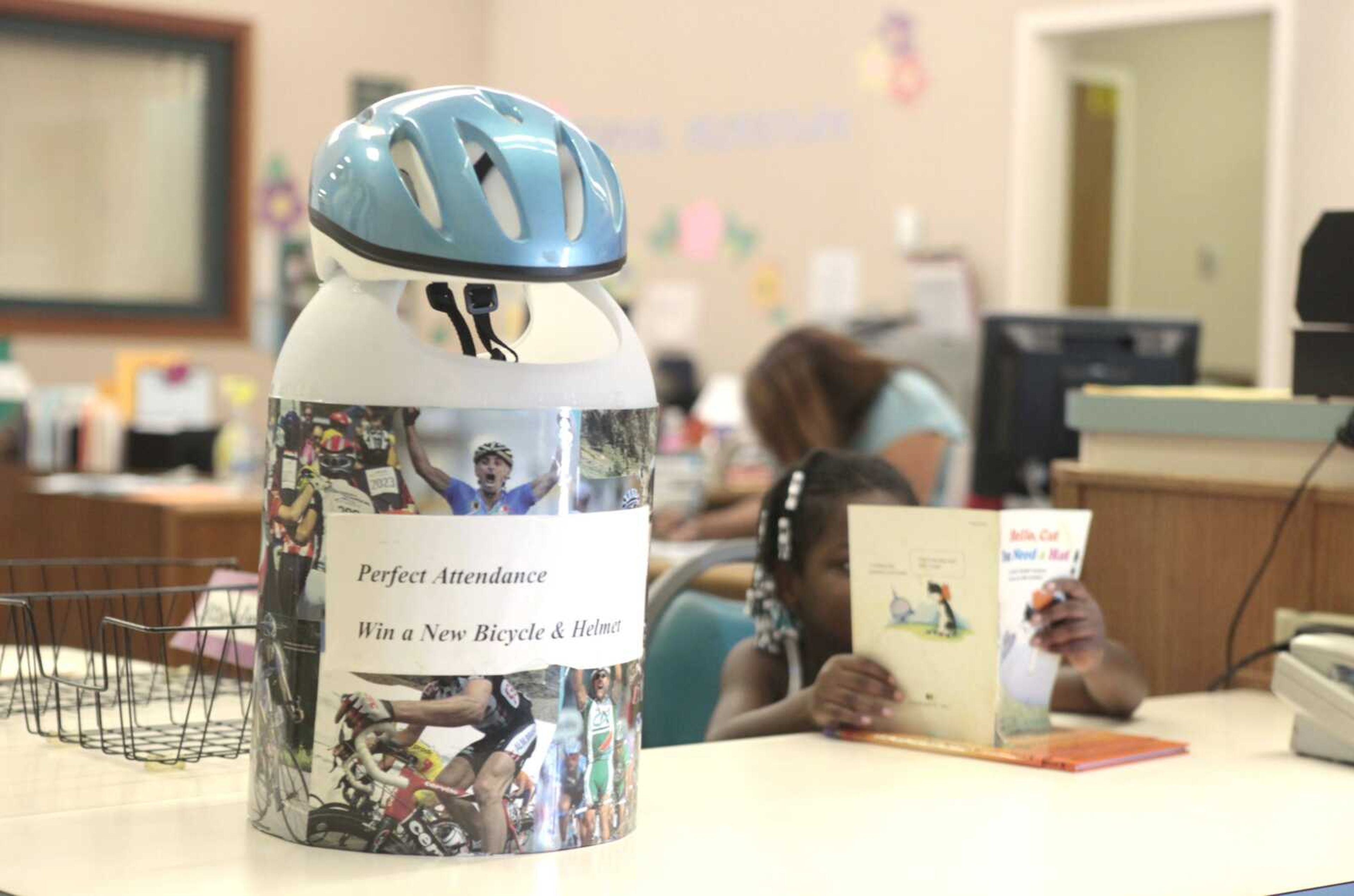 A bicycle helmet tops the container where students with a month&#8217;s worth of perfect attendance can enter their names in a raffle to win the helmet and bicycle Aug. 29 at the Maeola R. Beitzel Elementary School in Sacramento, Calif. (Rich Pedroncelii ~ Associated Press)