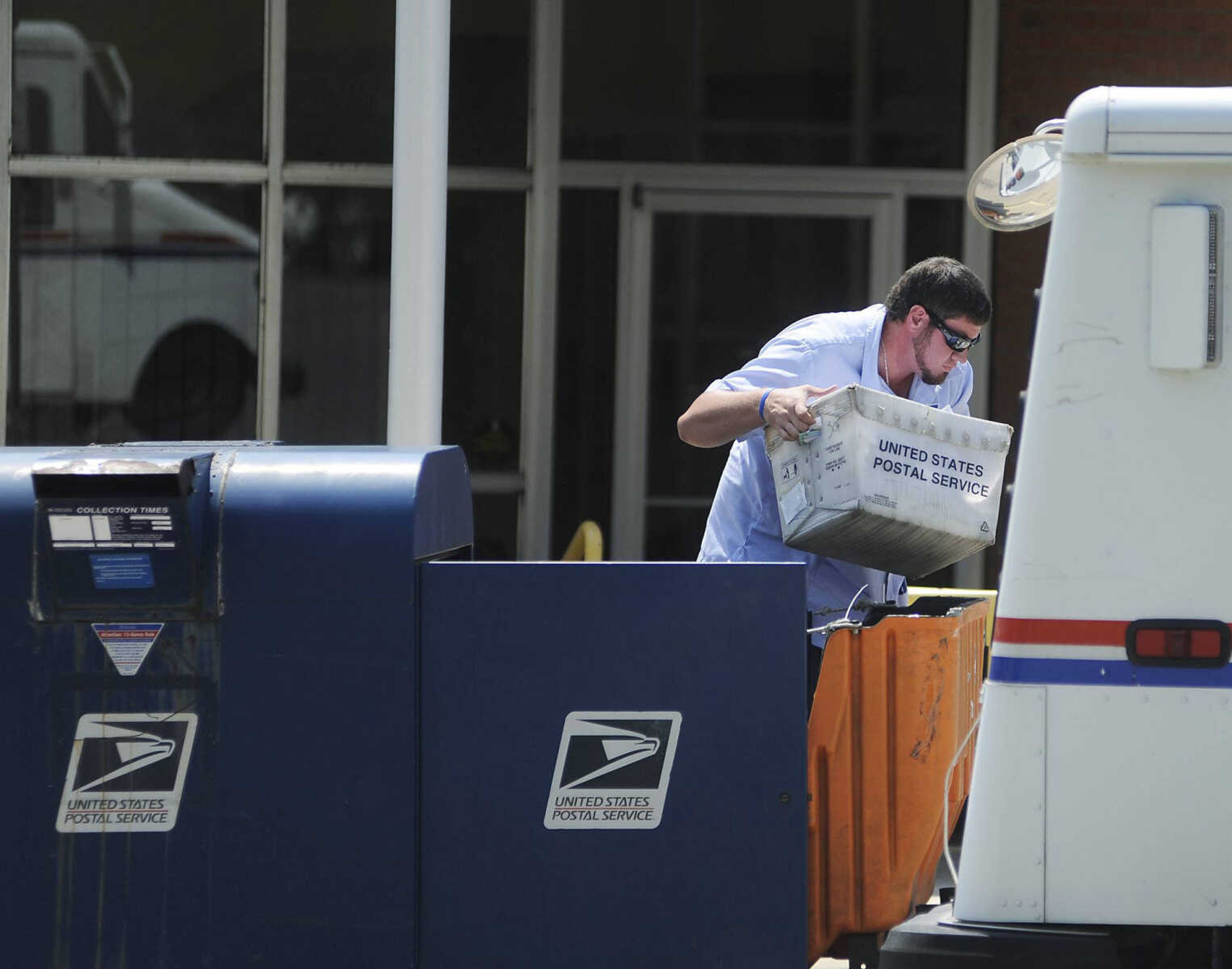 A postal worker empties outgoing mail from a mailbox Tuesday, Aug. 20, at the Post Office at 320 N. Frederick St., in Cape Girardeau. (Adam Vogler)