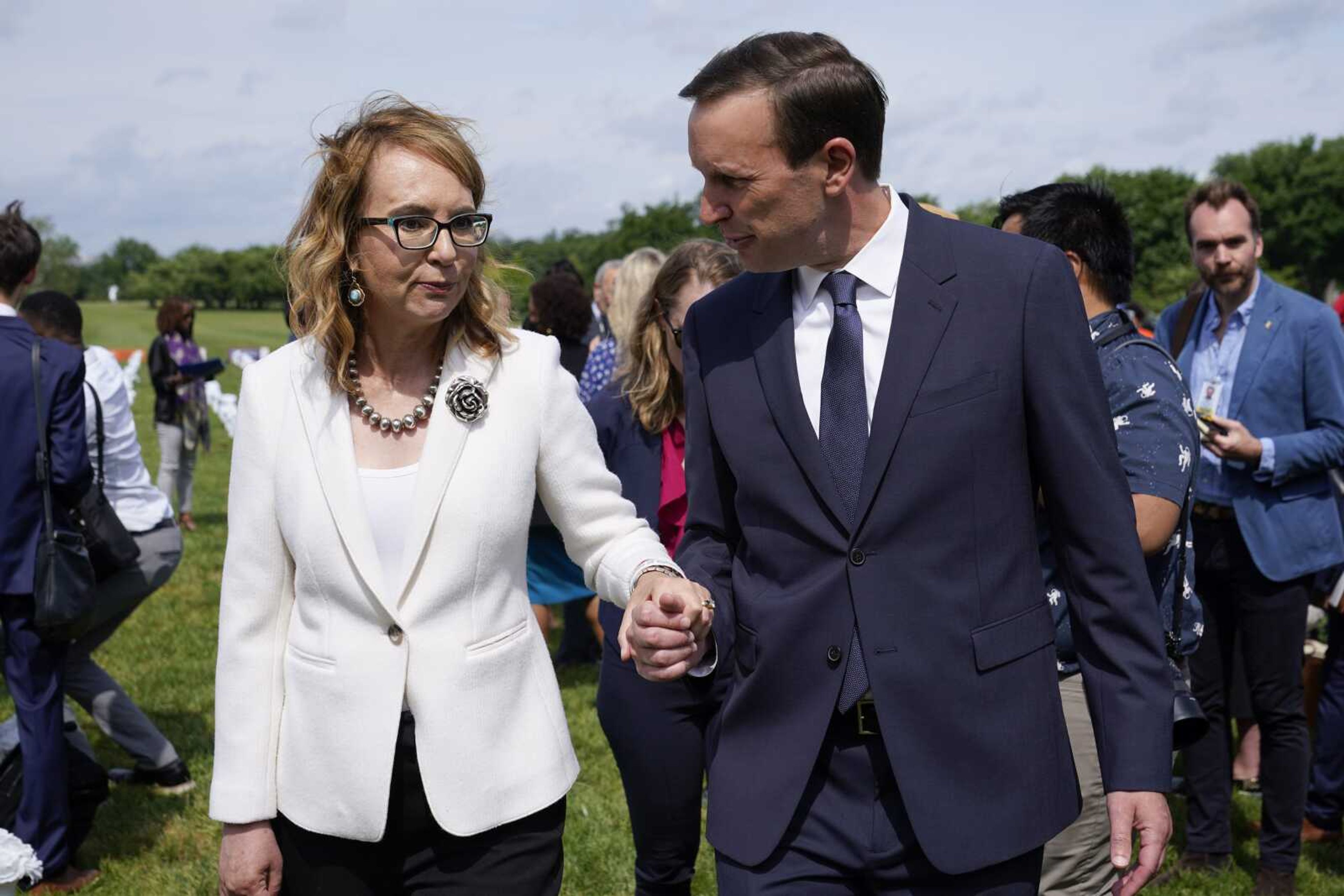 Former congresswoman and gun violence survivor Gabby Giffords, left, speaks with Sen. Chris Murphy, D-Conn., Tuesday at a Gun Violence Memorial installation on the National Mall in Washington.