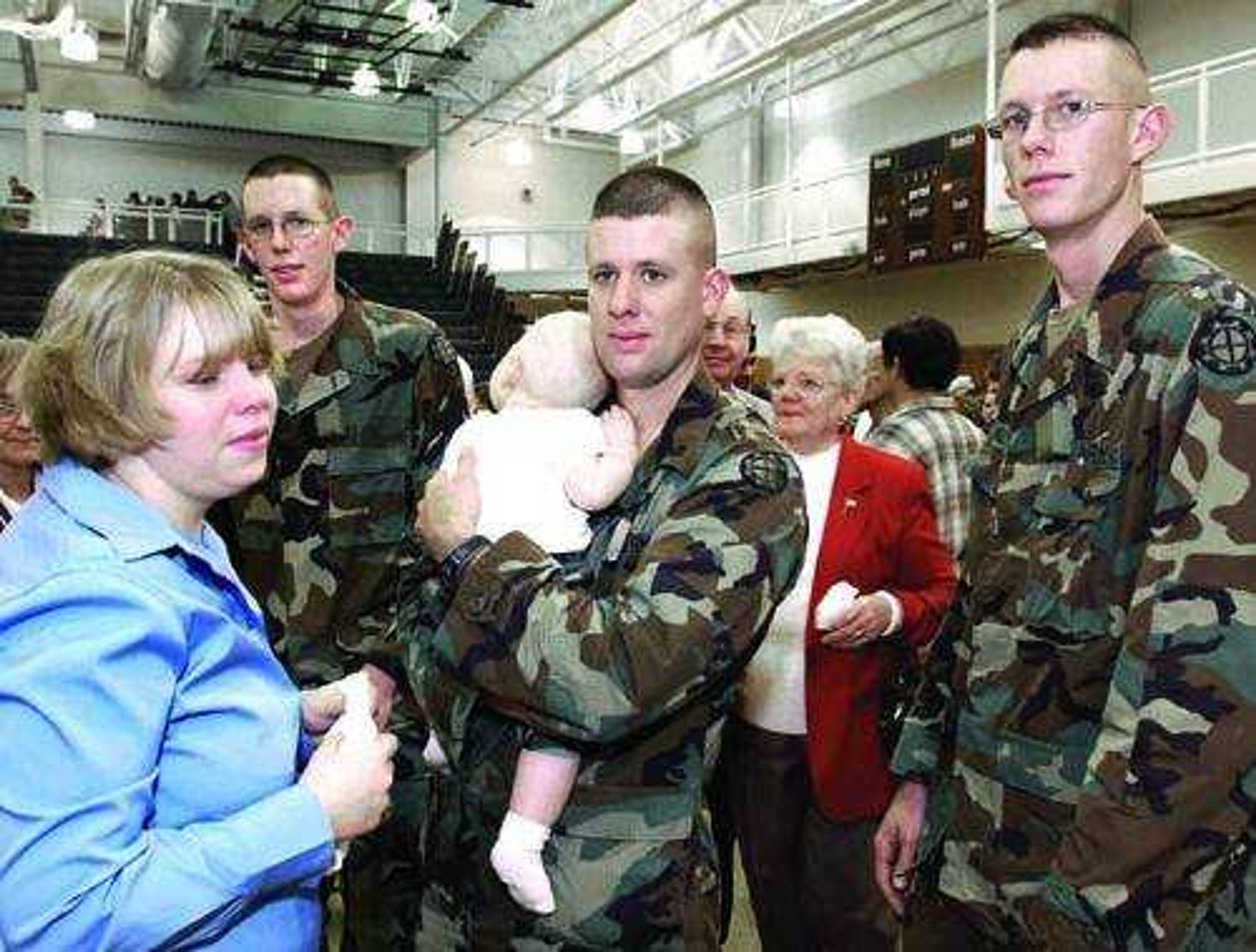 Brothers Patrick Meyer, John Meyer and Michael Meyer said their goodbyes to friends and family during Sunday's Army National Guard deployment ceremony held at the Perry Park Center in Perryville, Mo. John Meyer's wife, Tasha, left, and their 8-month-old son, Caleb, attended the ceremony.