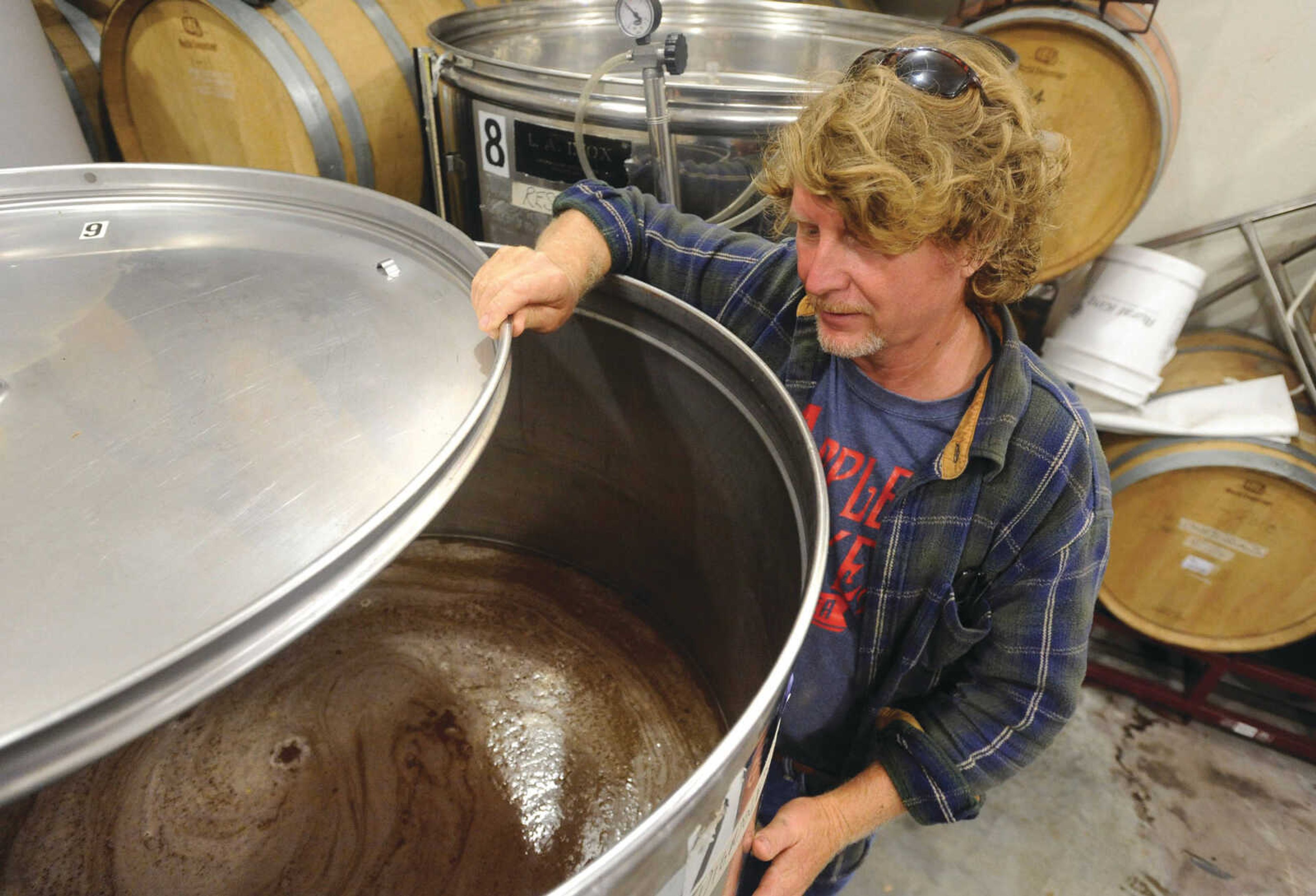 Brad Genung looks into a tank filed with Vignoles in the tank room at Owl Creek Vineyard.