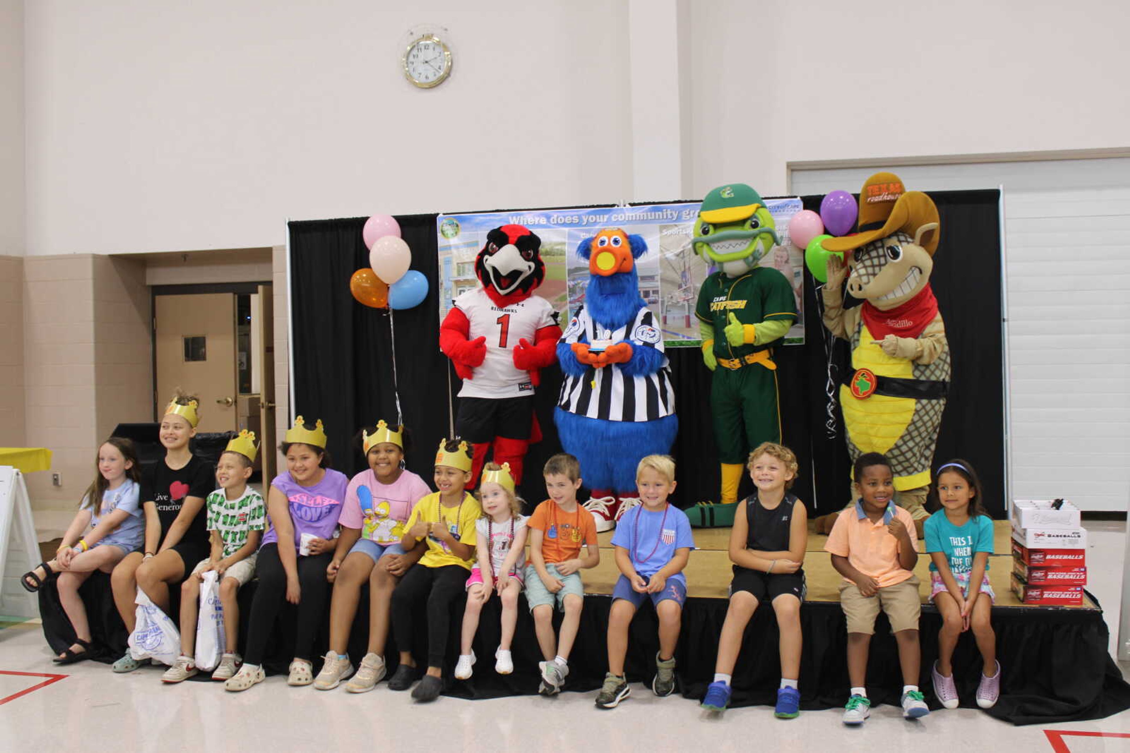 Children gather around for a photo after singing Happy Birthday to PLAYMO.