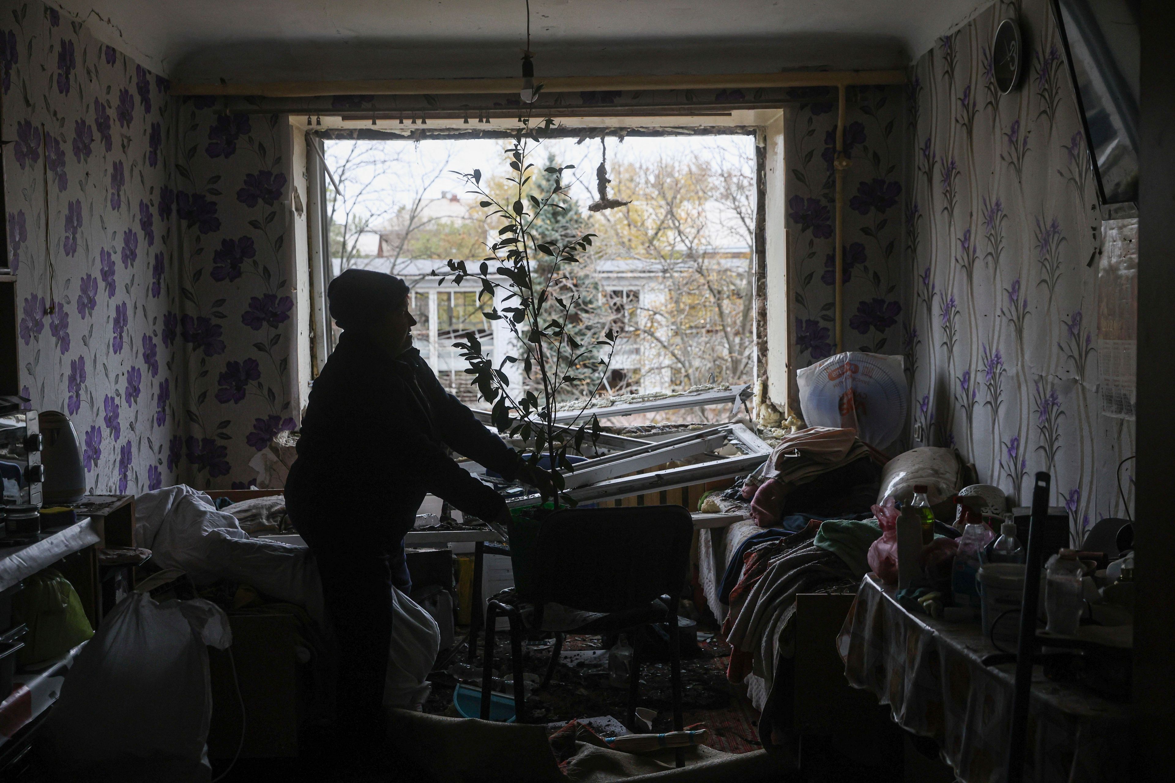 Natalia Panasenko clears rubble inside her room at a hostel for displaced people that was damaged by a Russian strike on a residential neighborhood in Zaporizhzhia, Ukraine, Nov. 11, 2024. (AP Photo/Kateryna Klochko)