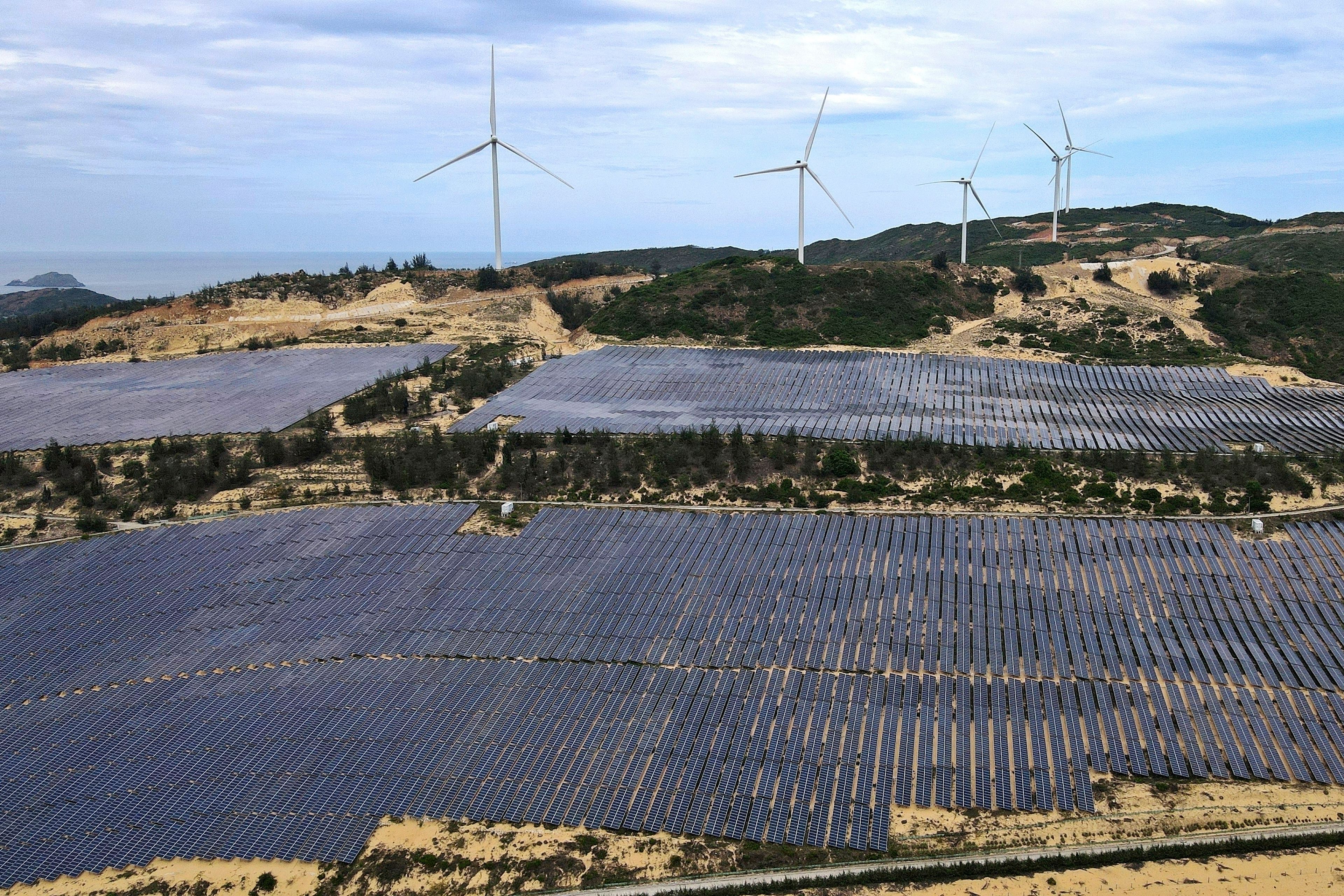 FILE - A solar farm operates near wind turbines in Quy Non, Vietnam on June 11, 2023. (AP Photo/Minh Hoang, File)