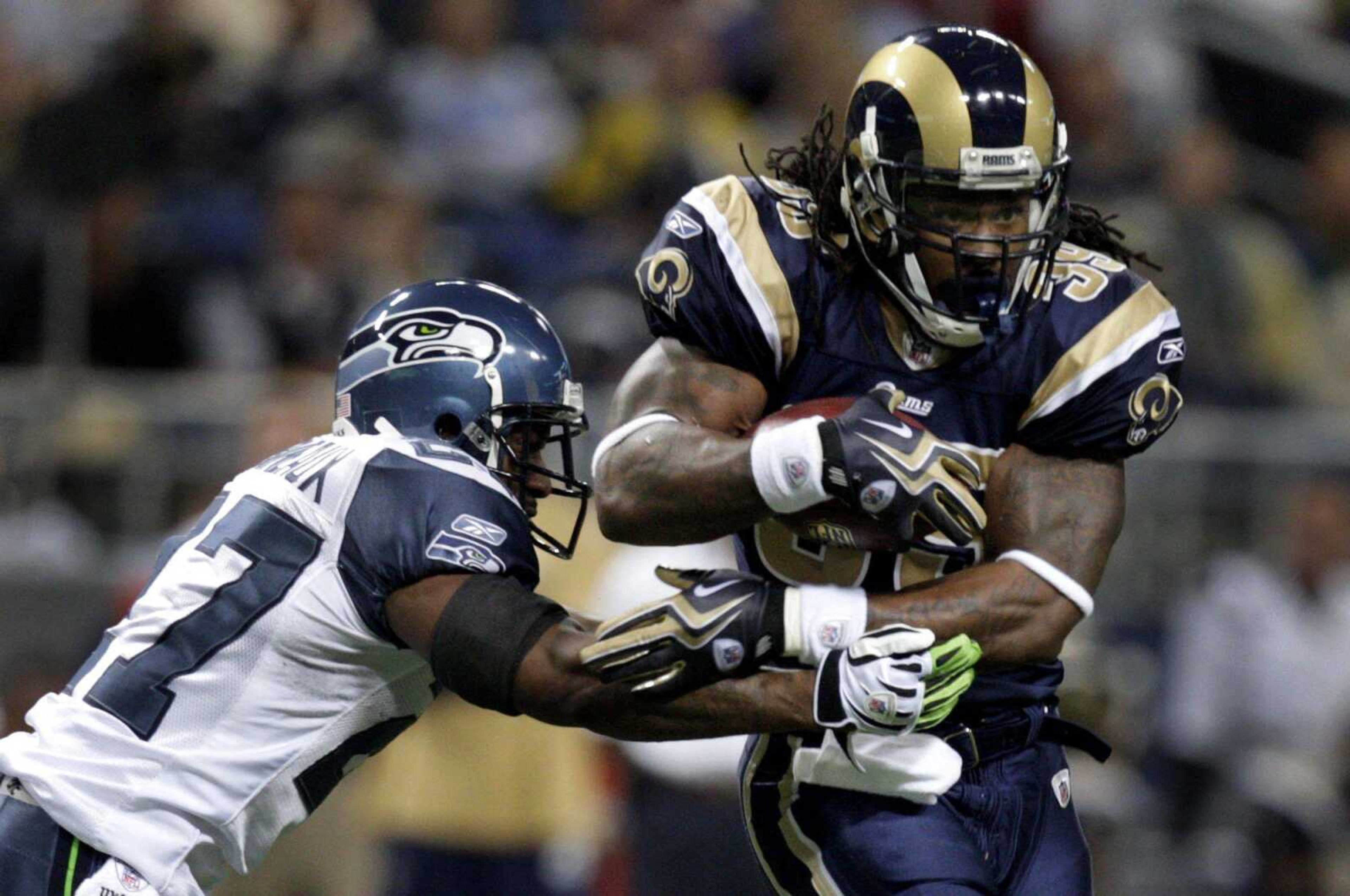 St. Louis Rams running back Steven Jackson, right, runs for a short gain before being brought down by Seattle Seahawks safety Jordan Babineaux during the first quarter of an NFL football game Sunday, Nov. 29, 2009, in St. Louis. (AP Photo/Jeff Roberson)