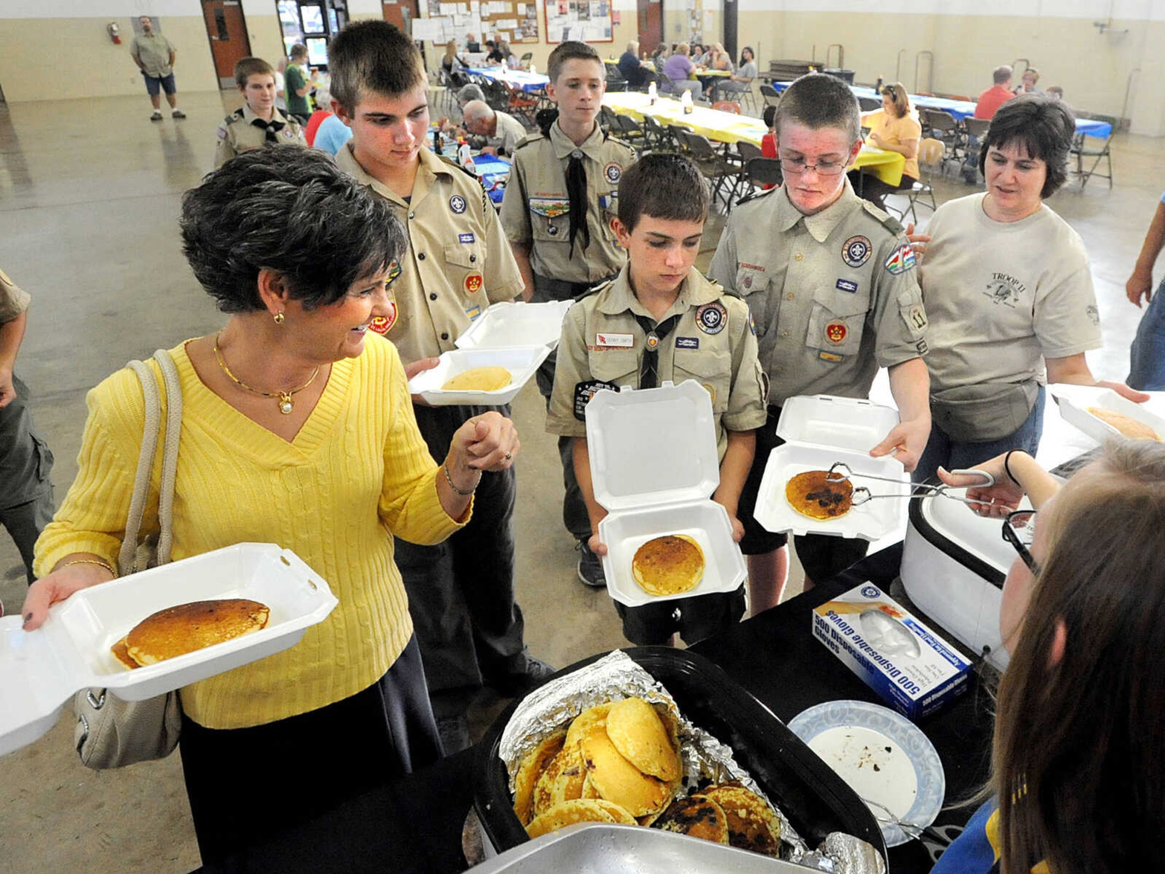 LAURA SIMON ~ lsimon@semissourian.com
Diana Balsam receives help from Troop 11 Boy Scouts Kyle Stedman, Denny Smith, Hunter Yates and Boy Scout mother Donna Stedman as she gets carry outs for her family Tuesday, Oct. 23, 2012 during the Jackson Rotary Pancake Day at the National Guard Armory. People could pick from plain, chocolate chip, pecan and blueberry pancakes and a side of sausage.