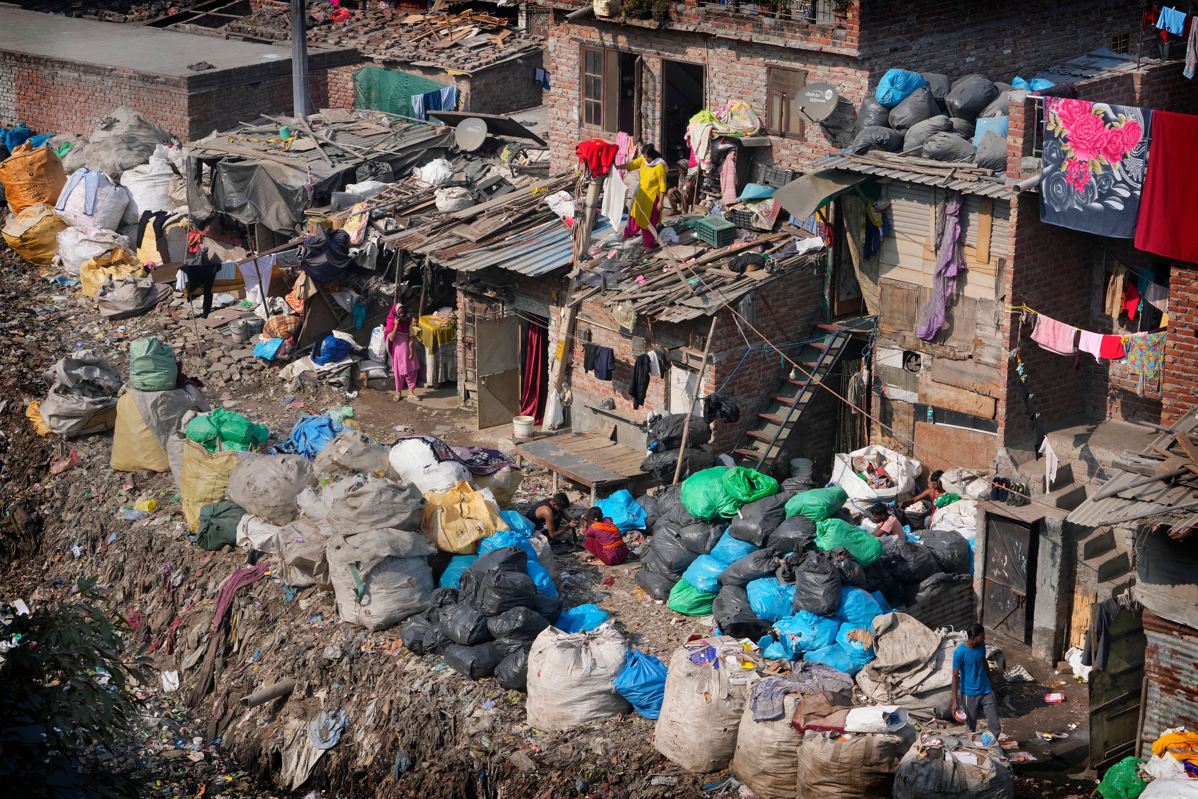 People store various waste materials in plastic sacks for sorting out in New Delhi, India, Tuesday, Nov. 26, 2024. (AP Photo/Manish Swarup)