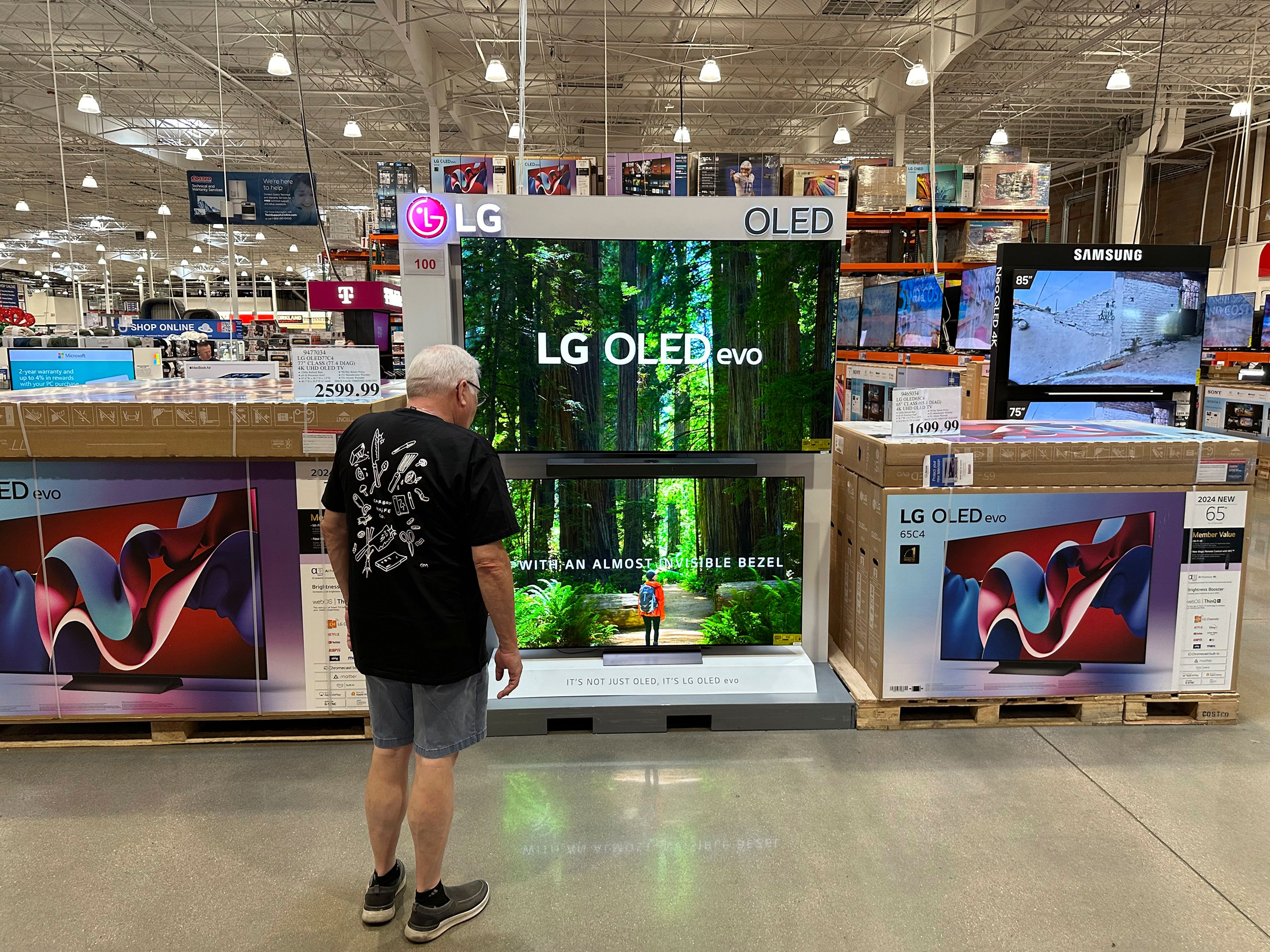 A shopper examines large-screen televisions on display in a Costco warehouse Thursday, Sept. 19, 2024, in Lone Tree, Colo. (AP Photo/David Zalubowski)