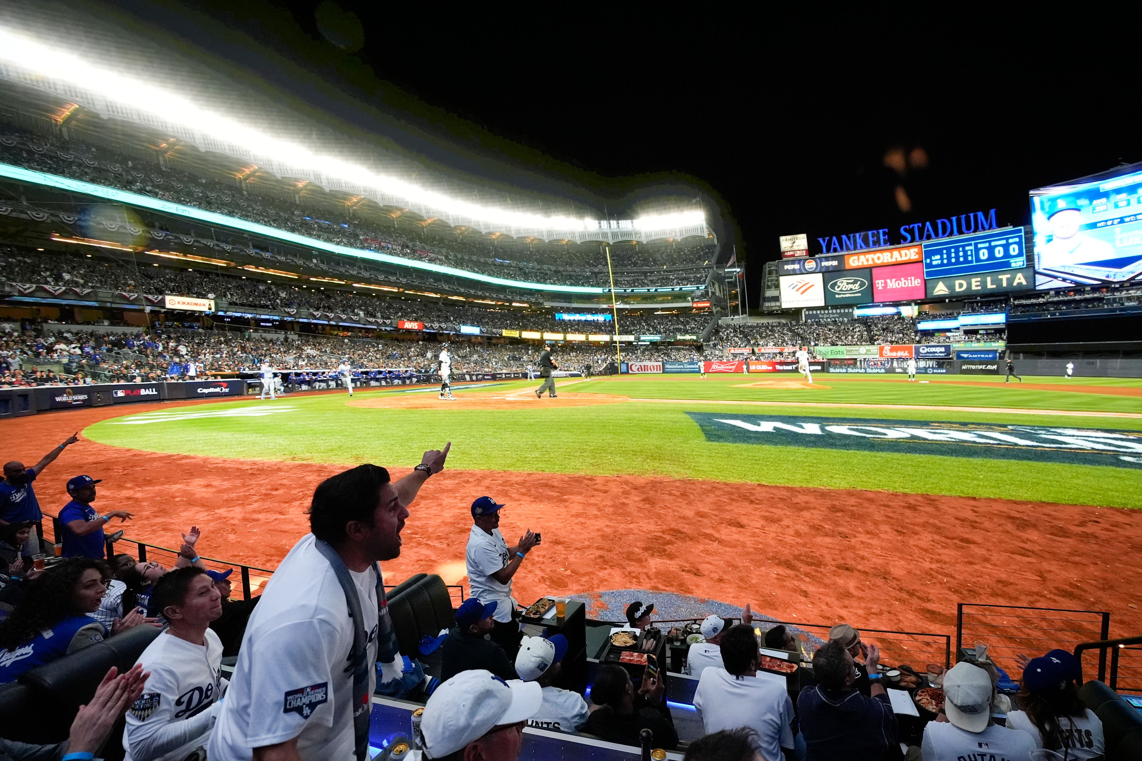 Fans watch a broadcast of Game 4 of baseball's World Series between the Los Angeles Dodgers and the New York Yankees at Cosm in Inglewood, Calif., Tuesday, Oct. 29, 2024. (AP Photo/Jae C. Hong)