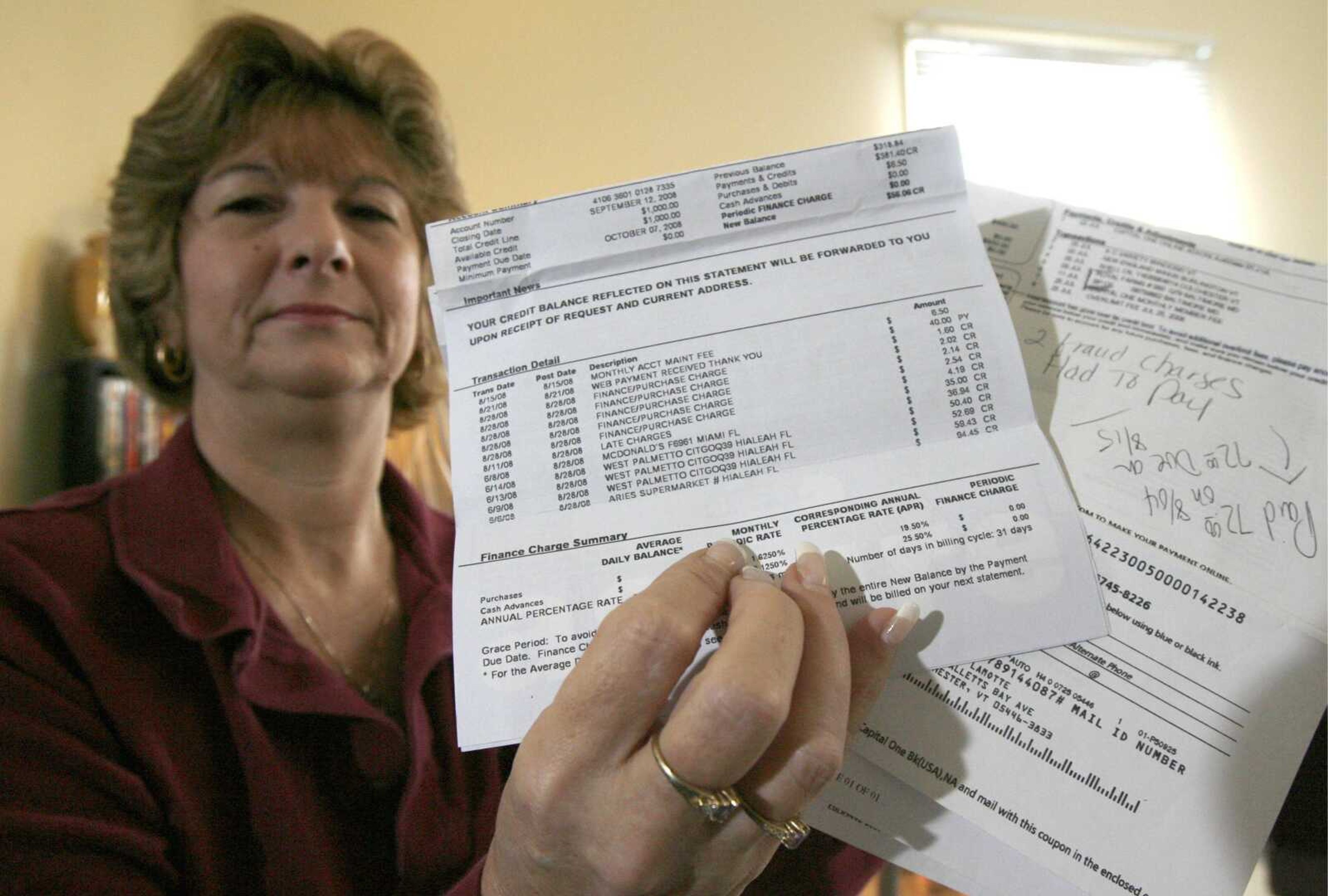 Pamela LaMotte holds disputed credit card bills Feb. 25 for a closed account, left, and an open one in Colchester, Vt. More than 4 million card numbers were stolen from Hannaford Bros. Co., an East Coast supermarket chain. (Toby Talbot ~ Associated Press)