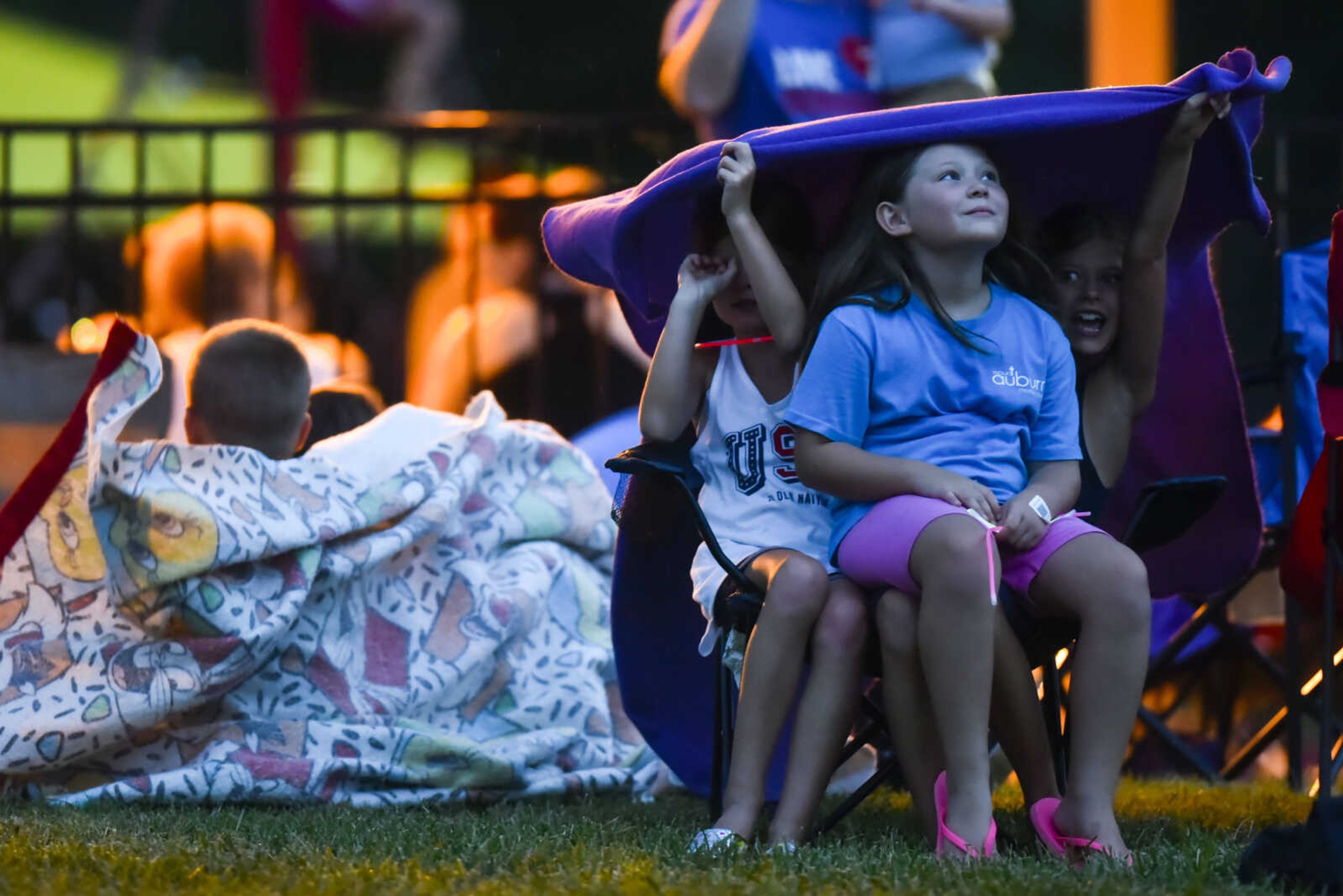 Children take shelter under a blanket as storm clouds roll in Tuesday, July 3, 2018, prior to the start of the Missouri Veterans Home fireworks show in Cape Girardeau.