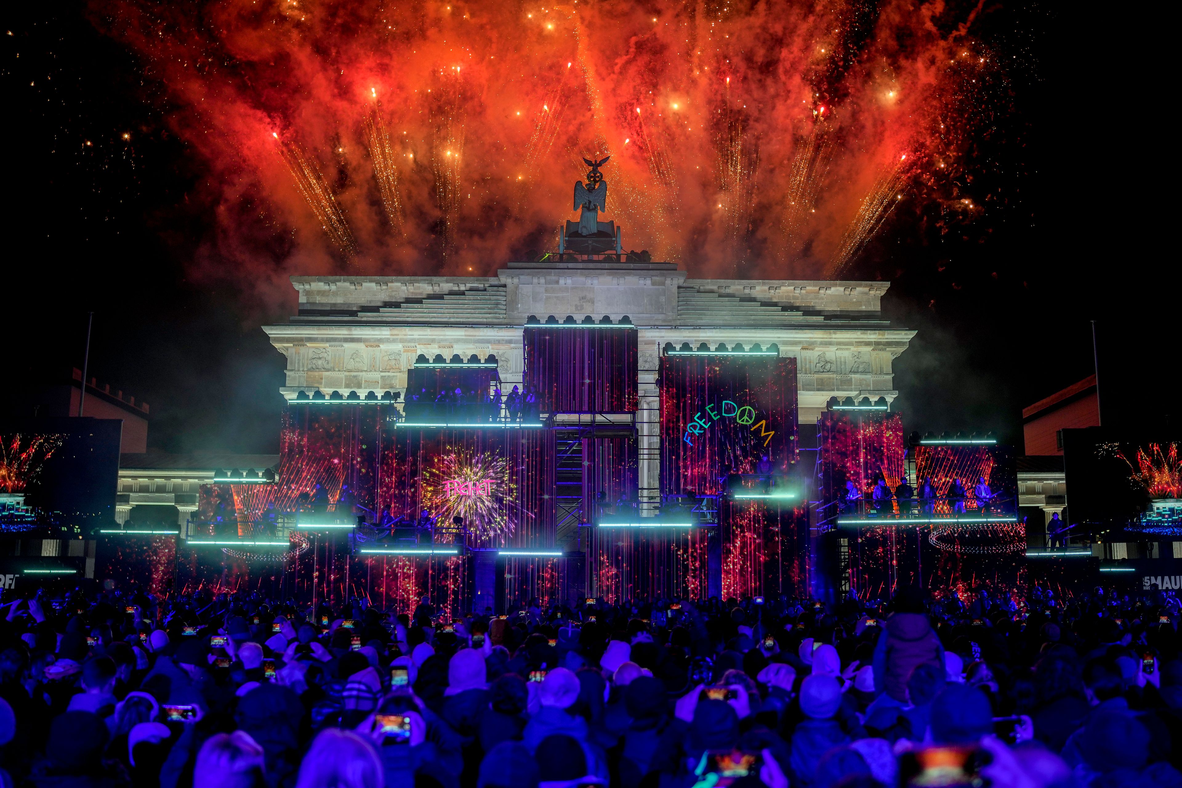 Fireworks light the sky as musicians play on stage during the concert for freedom for the 35th anniversary of the fall of the Berlin Wall, in Berlin, Germany, Saturday, Nov. 9, 2024. (AP Photo/Ebrahim Noroozi)