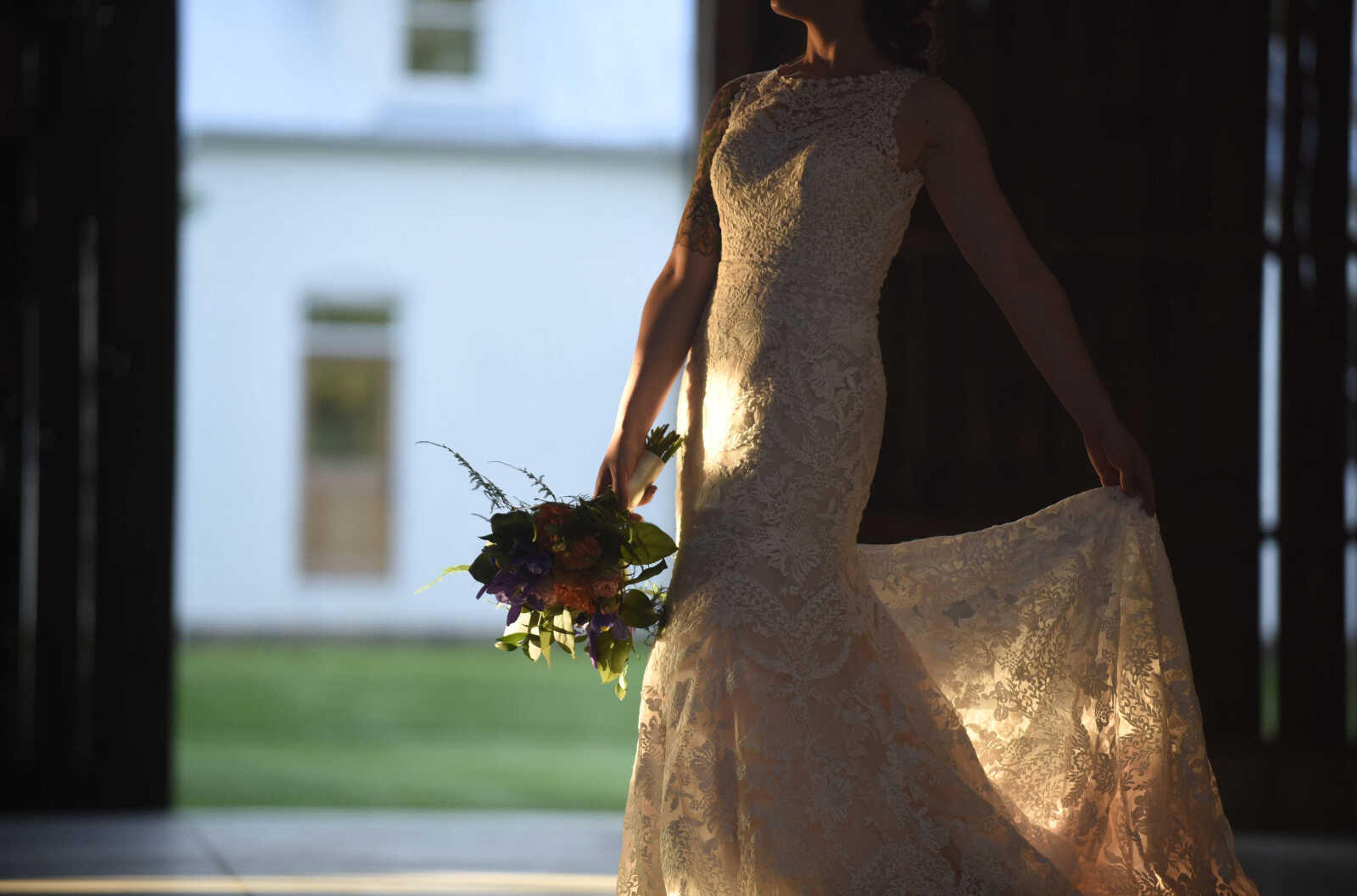 This Eddy K dress is a fit and flare, ivory on champagne colored gown. It has heavily embroidered symmetrical lace over velure tulle, with a detailed illusion back. Available at Ann-Louise Bridal in Jackson.