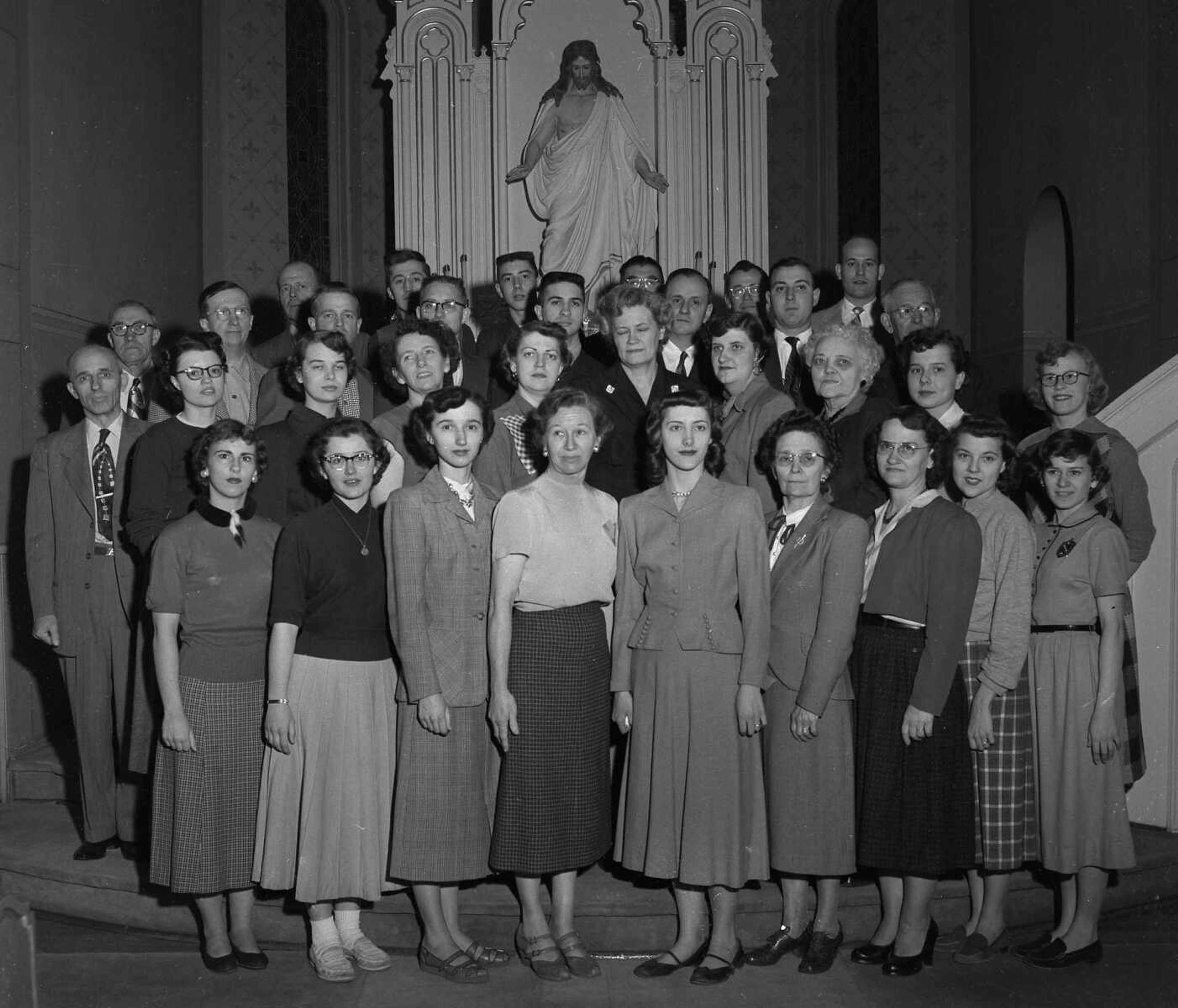 Robert Brinkopf of Effingham, Ill., identified this photograph as having been published in a booklet marking the 100th anniversary of Trinity Lutheran Church in Cape Girardeau in 1954.
Front row, left to right: Grace Baumann, Carol Rudert, Mrs. Irvin Rasche, accompanist, Mrs. William Luckmann, Norma Steinbach, Lena Weber, Mrs. Melvin Haertling, Mrs. Paul Gerlach, Patricia Parker. Second row: H.A. Krahn, director, Mrs. I.H. Crews, Mrs. Paul Brauer, Mrs. Alvert Hilpert, Laura Gerlach, Ida Daume, Ruth Froemsdorf, Mrs. Charlotte Davis, Lida Landgraf, Sally Edmonds. Third row: Martin Niedling, Clarence Bertling, Layton Keller, Don Popp, Carl Lehne, Albert Hilpert, Gene Popp, E.G. Rudert. Back row: A.E. Landgraf, Richard Dippold, Ronnie Hopper, Arthur Fischer, Gene Popp, Paul Brauer.
Brinkopf also observed that "Mr. Krahn was the eighth grade teacher and principal at the time. Miss Froemsdorf was a long time 3rd grade teacher at the school. Mr. Brauer, Miss Steinbach, and Miss Baumann were also teachers at the time."